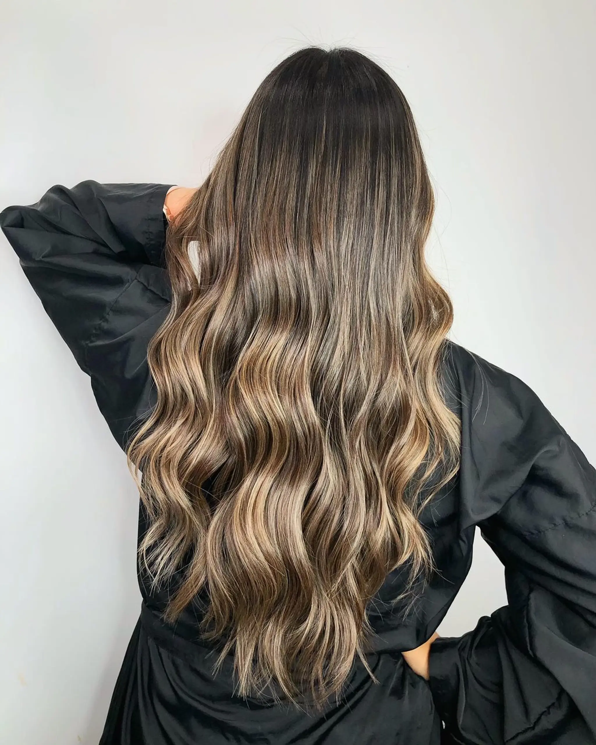 Long, wavy hair with a balayage transitioning from black to dark brown, into ash blonde highlights with a soft root shadow.
Stylist - @xcellent_jason