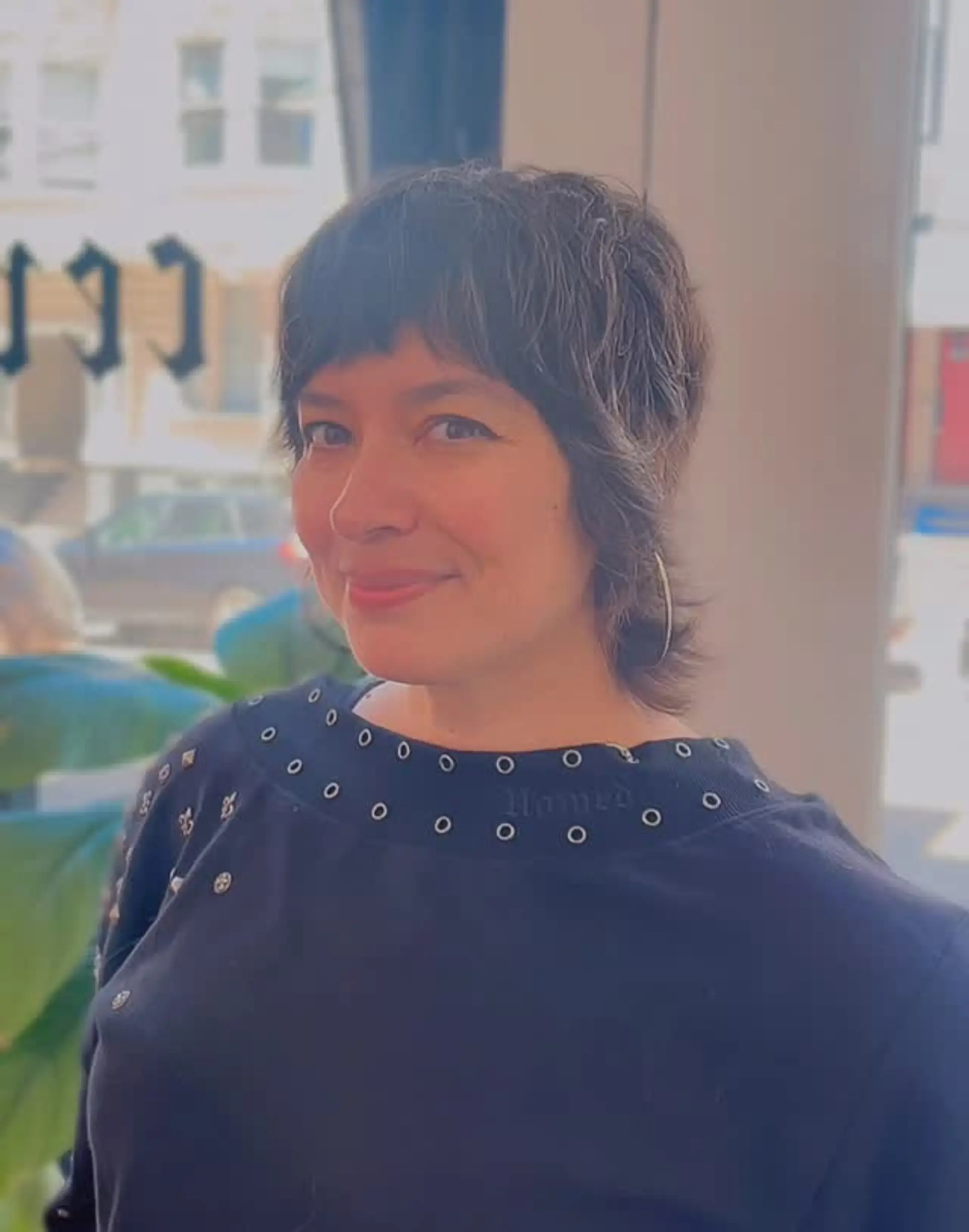 A textured, retro-inspired mod shag haircut featuring micro-fringe bangs, layered face-framing pieces, and soft neck-length feathering. 1