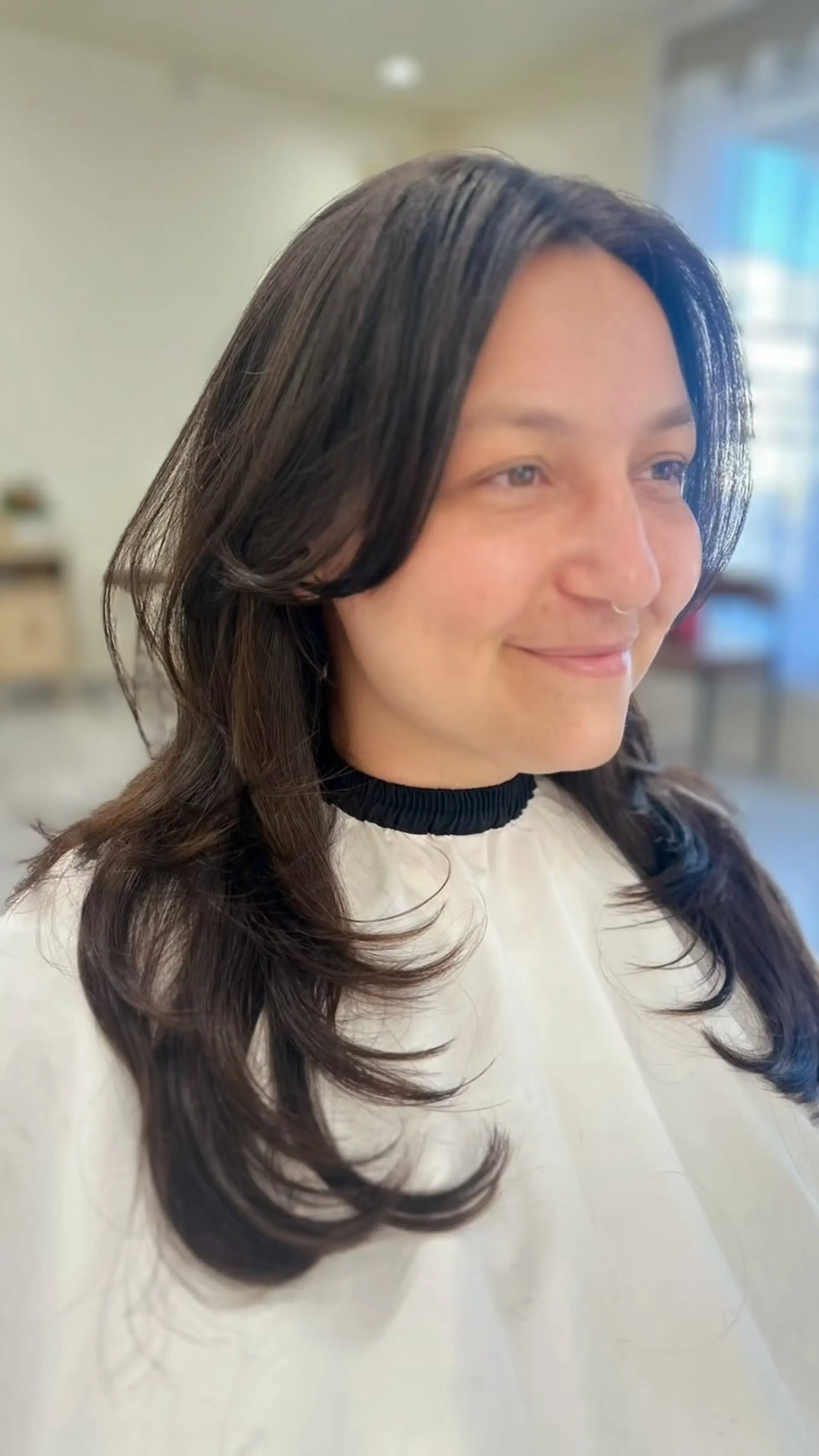 A soft layered hush cut with feathered face-framing curtain bangs and gently curved ends. 1