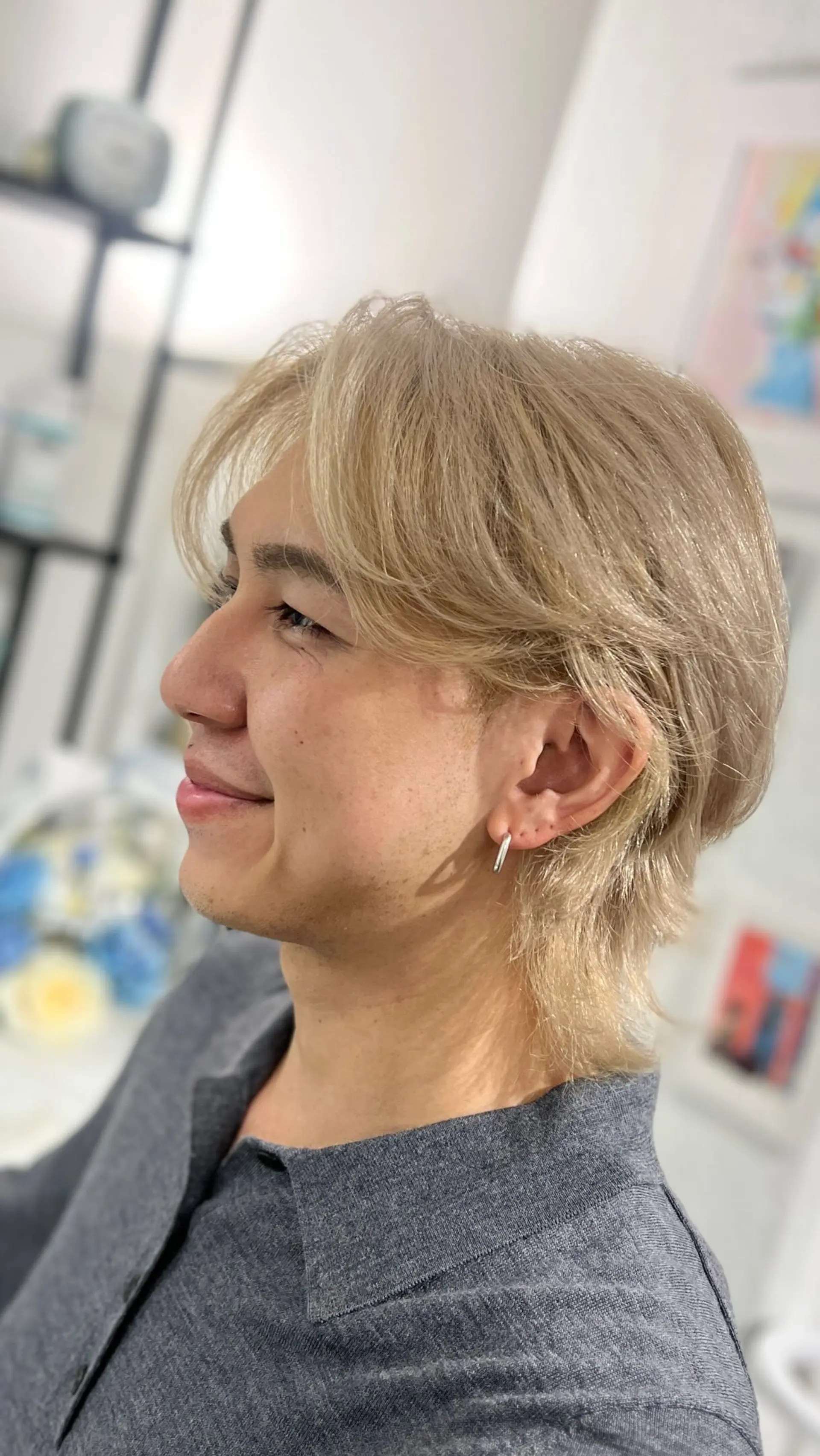 A textured beige blonde wolf cut featuring feathered layers, face-framing fringe, and a softly tapered nape. 1