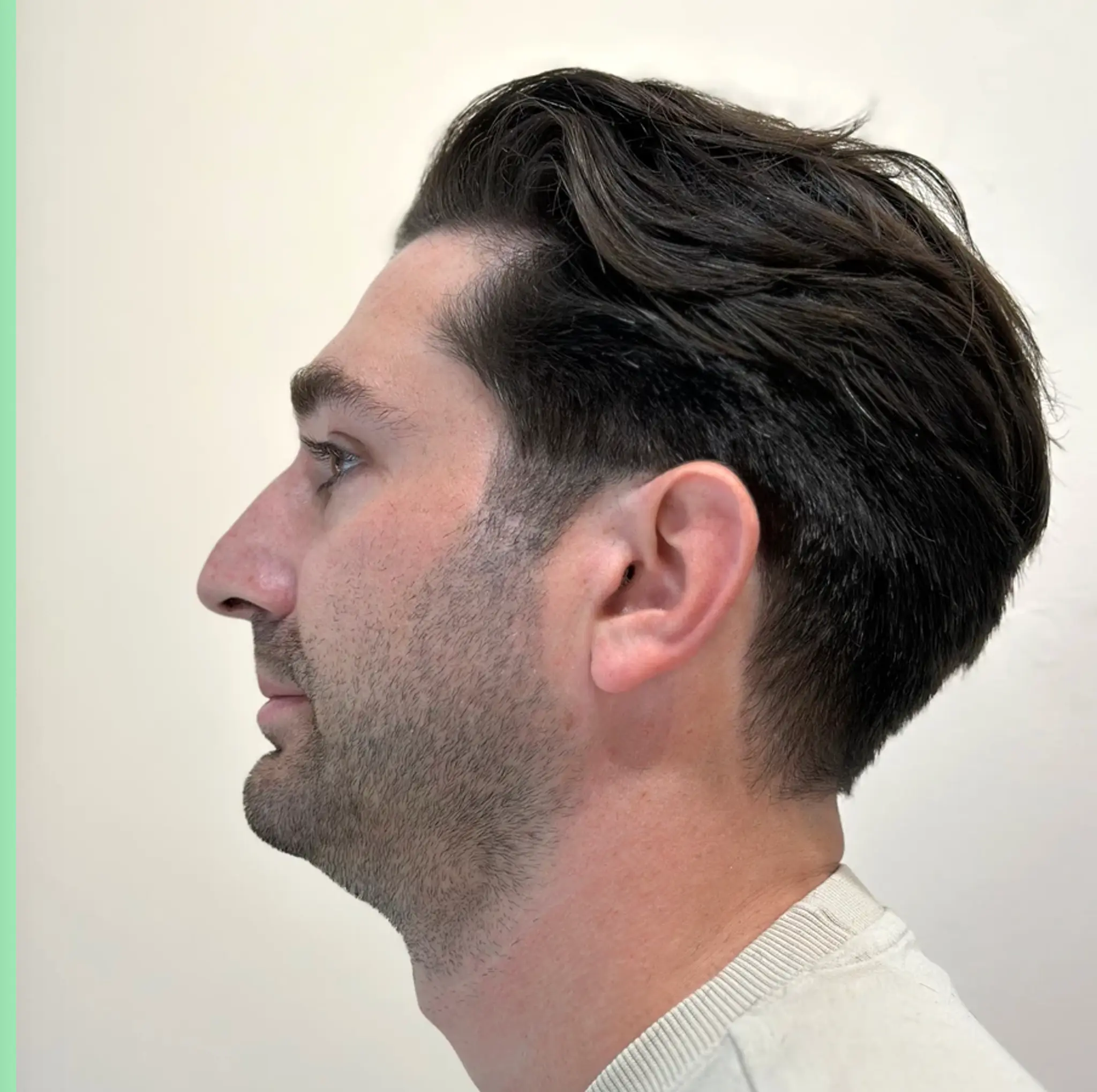 Wavy, slicked-back hairstyle with a tapered back and dark brown color.