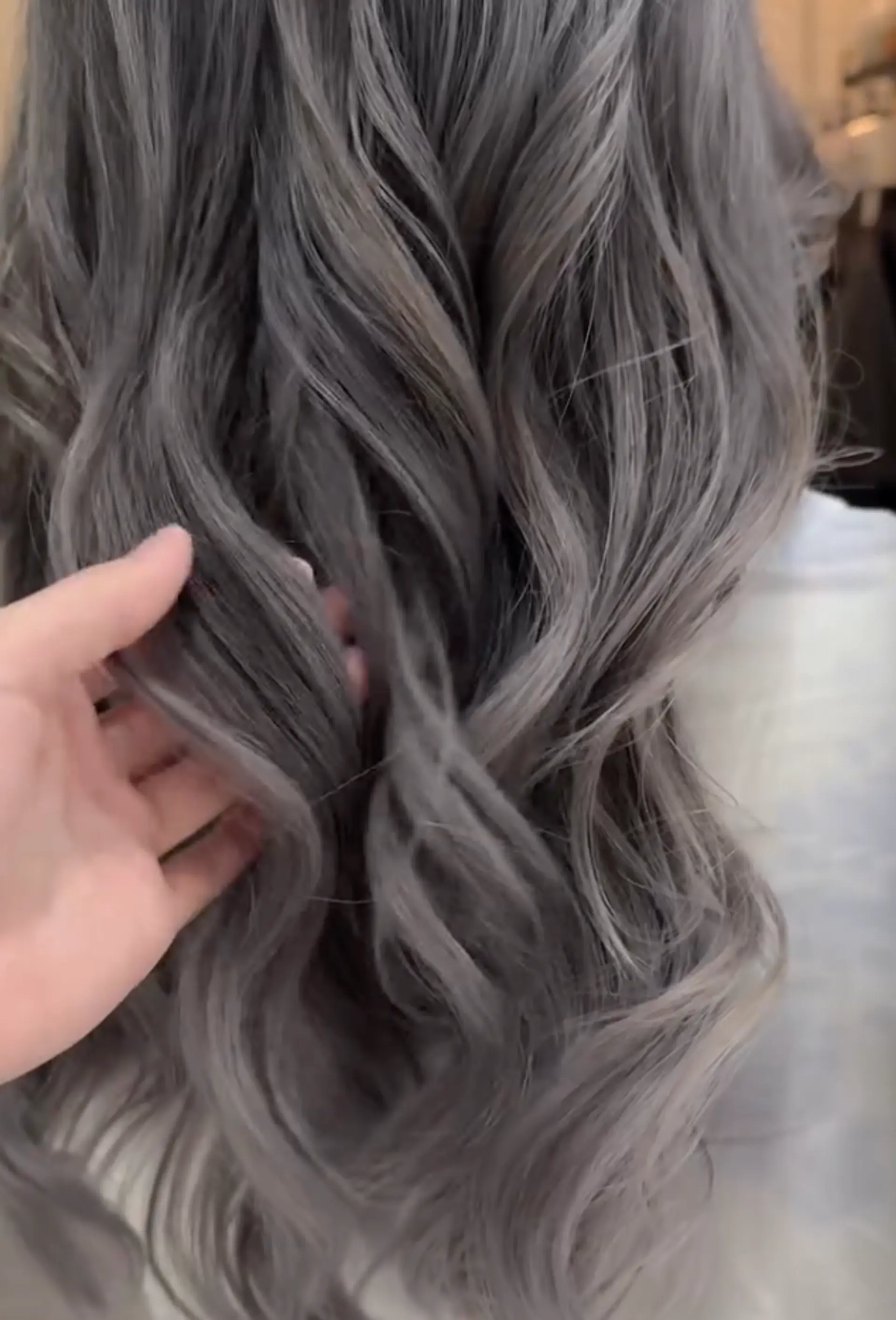 Long, wavy hair in ash gray and silver ombre with soft, loose curls and a layered cut.

Stylist: @yurihair.newyork 2