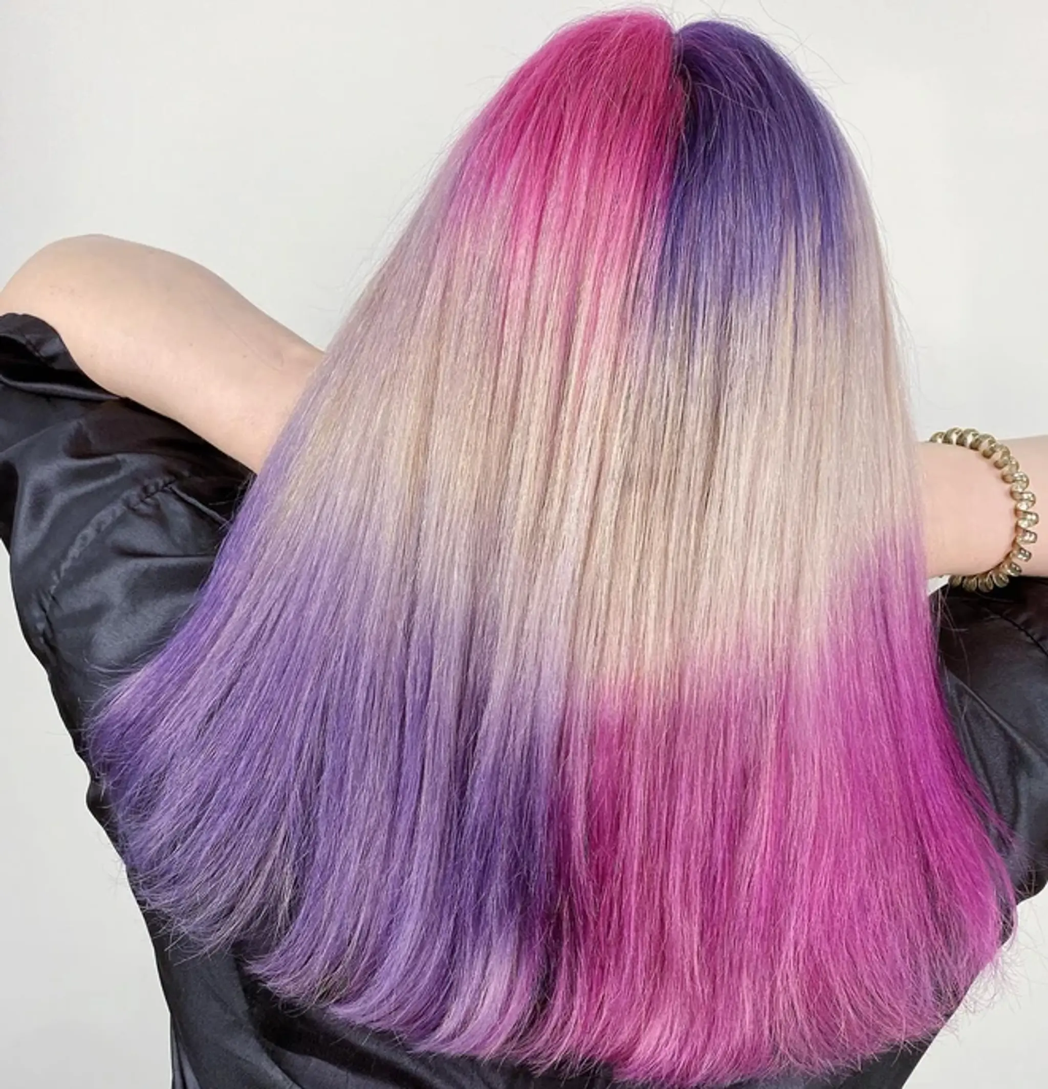 Long, straight hair with a striking ombre effect, transitioning from vibrant pink to deep purple and blending into pale blonde, with ends dipped in vivid pink.