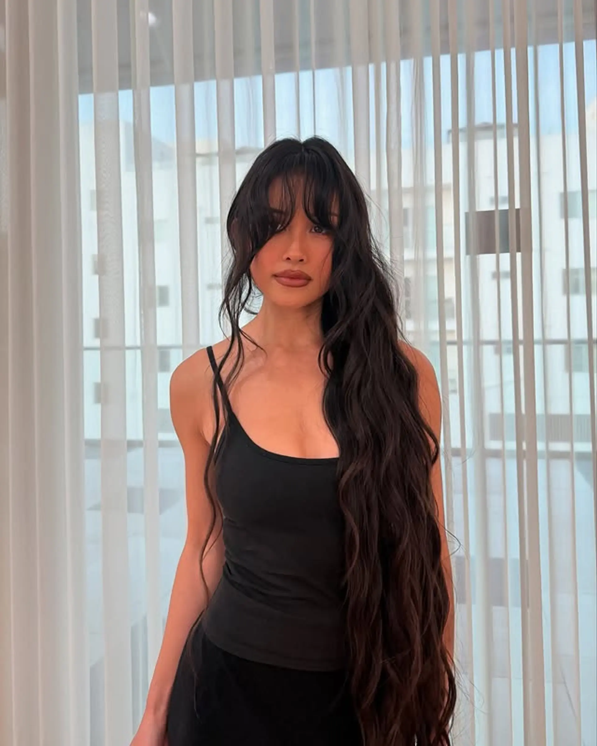 Very long, wavy brunette hair with flattering curtain bangs and face-framing layers. 1