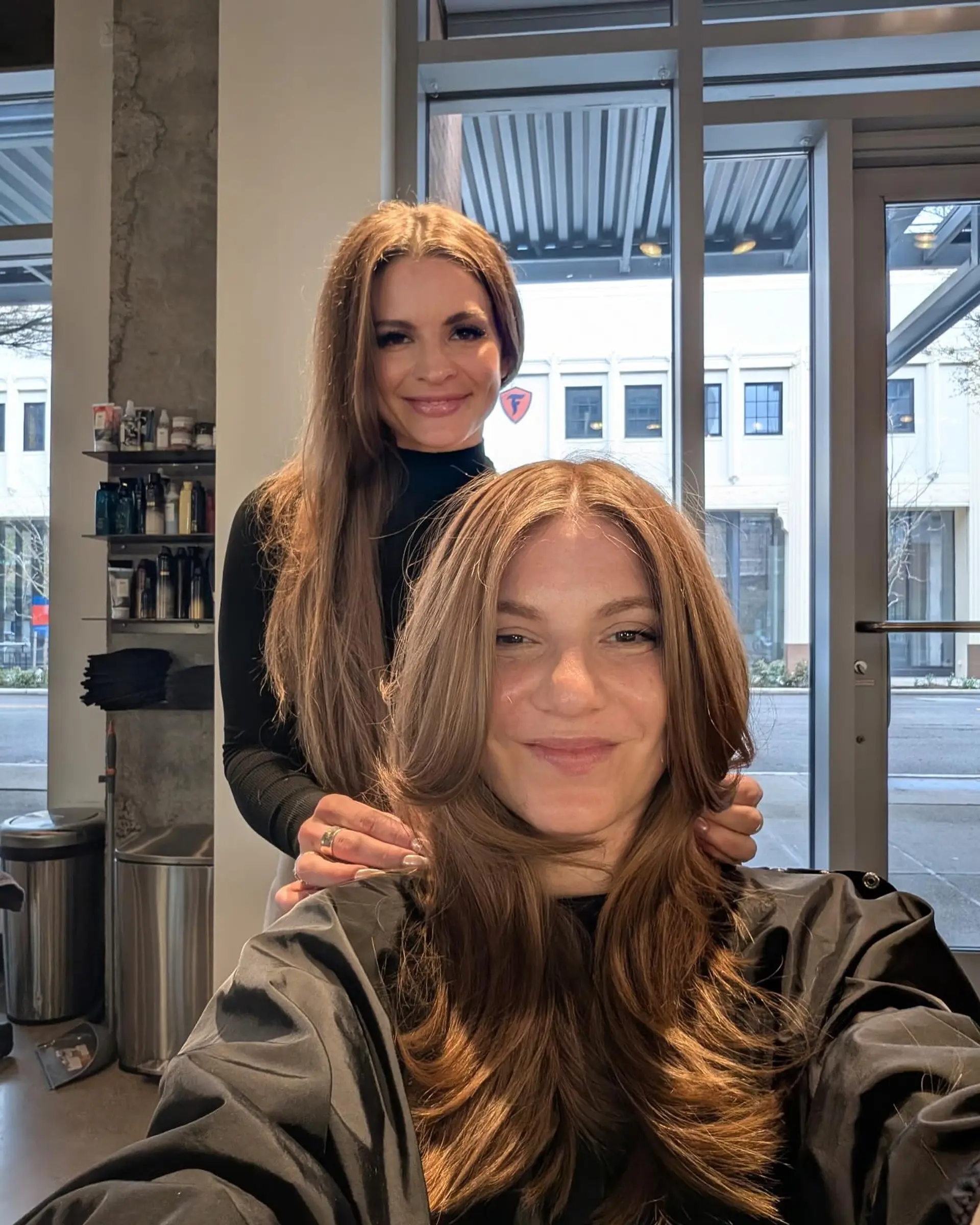 A long layered haircut styled with bouncy, face-framing curtain layers and soft feathered ends. 1