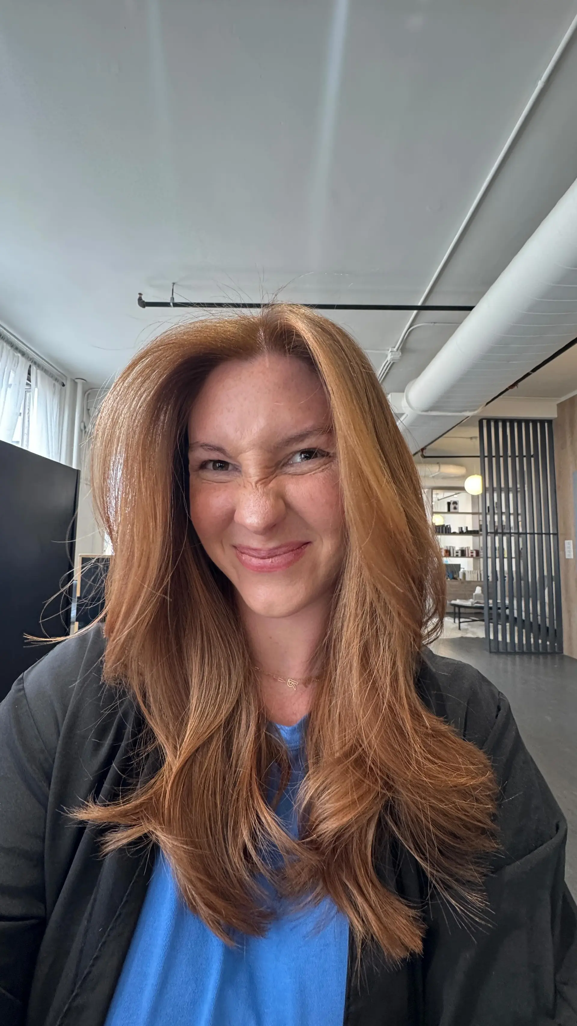 Long copper hair styled in a bouncy, voluminous blowout with feathered face-framing layers. 1