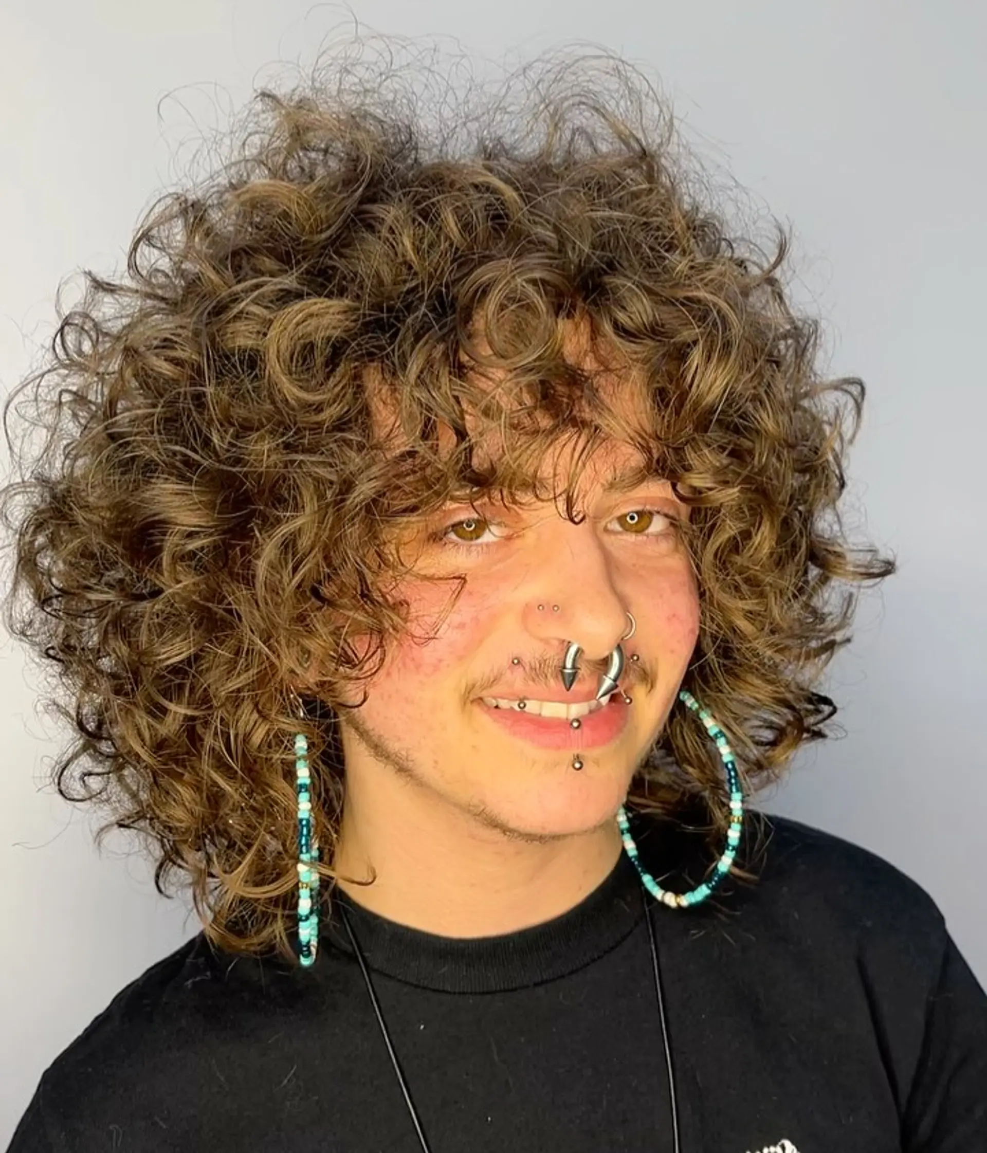 A voluminous curly shag featuring heavily layered rounded shaping and face-framing curly bangs. 1