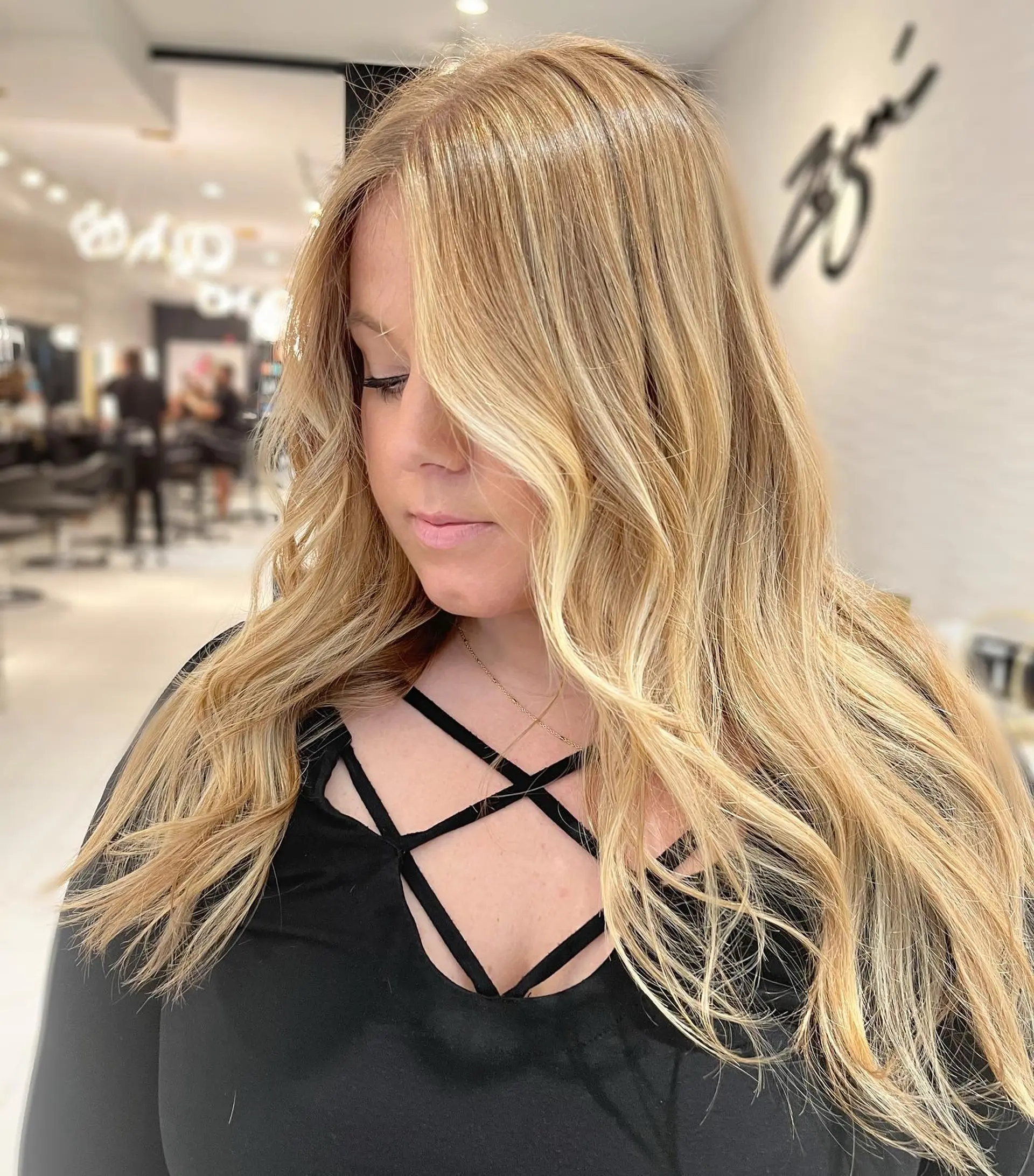 Long wavy hair with a golden blonde balayage, creating a dimensional and sun-kissed look. 1