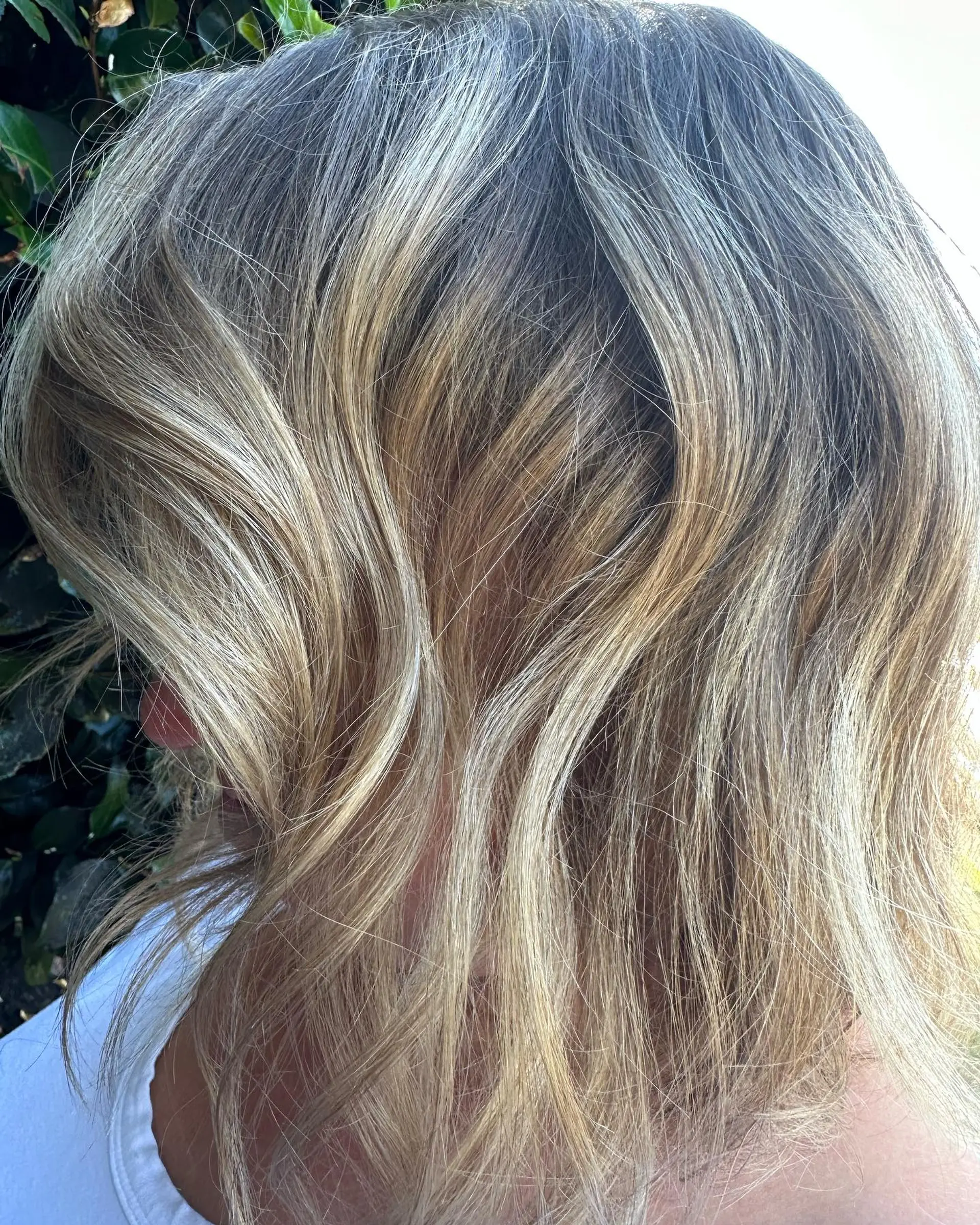 Medium-length textured lob with hand-painted dimensional blonde balayage and soft, lived-in waves. 1