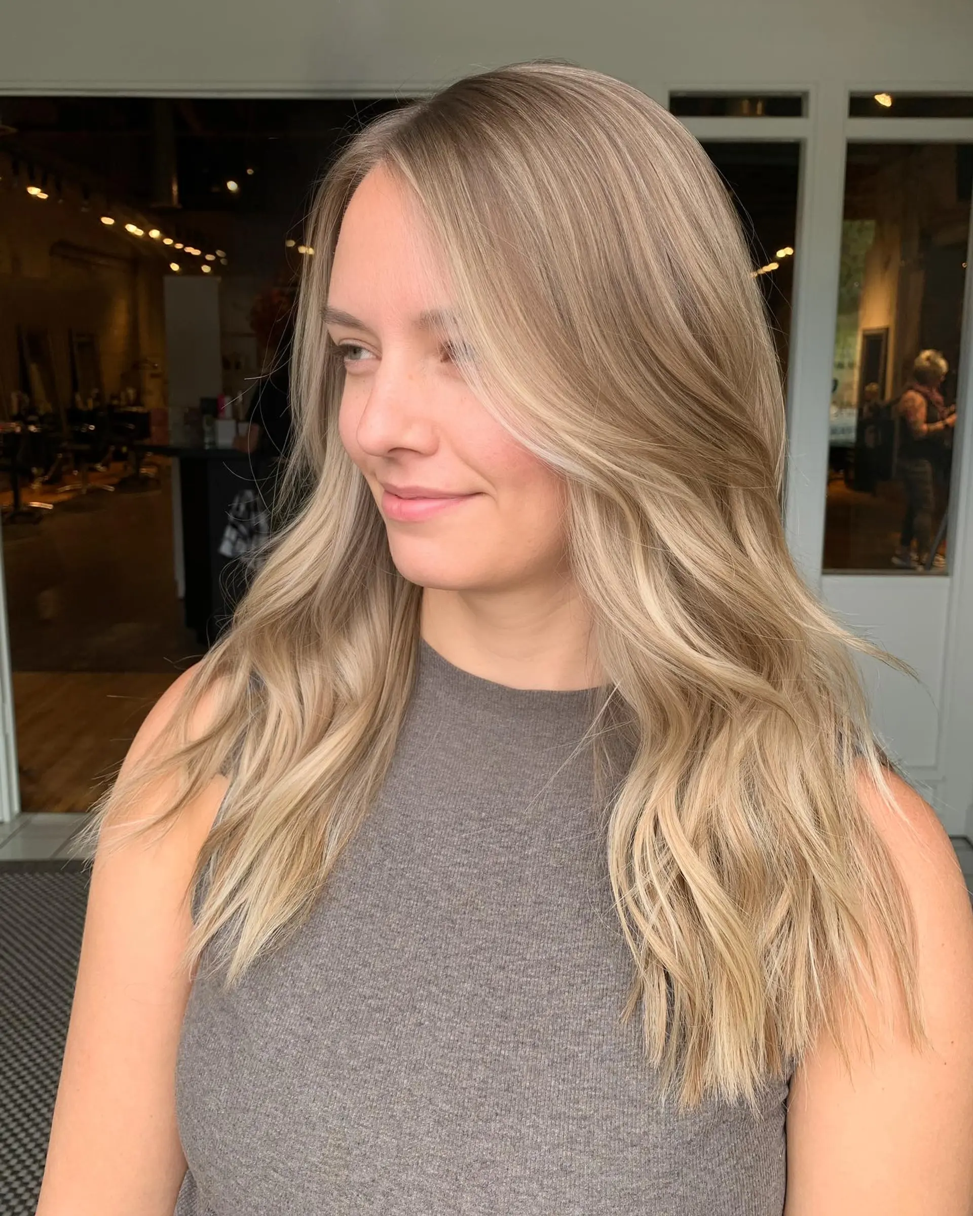 Long dimensional ash blonde hair with bright face-framing highlights and soft, loose waves. 1