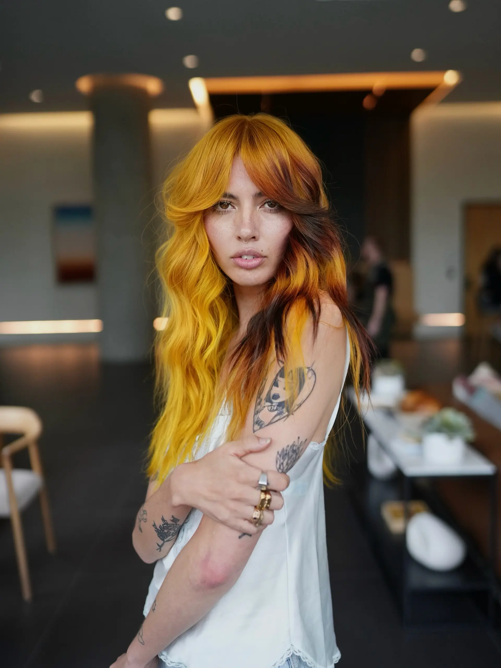 A layered long shag with feathered curtain bangs featuring vibrant golden-yellow and burnt orange tones contrasted with deep brown color blocking. 1