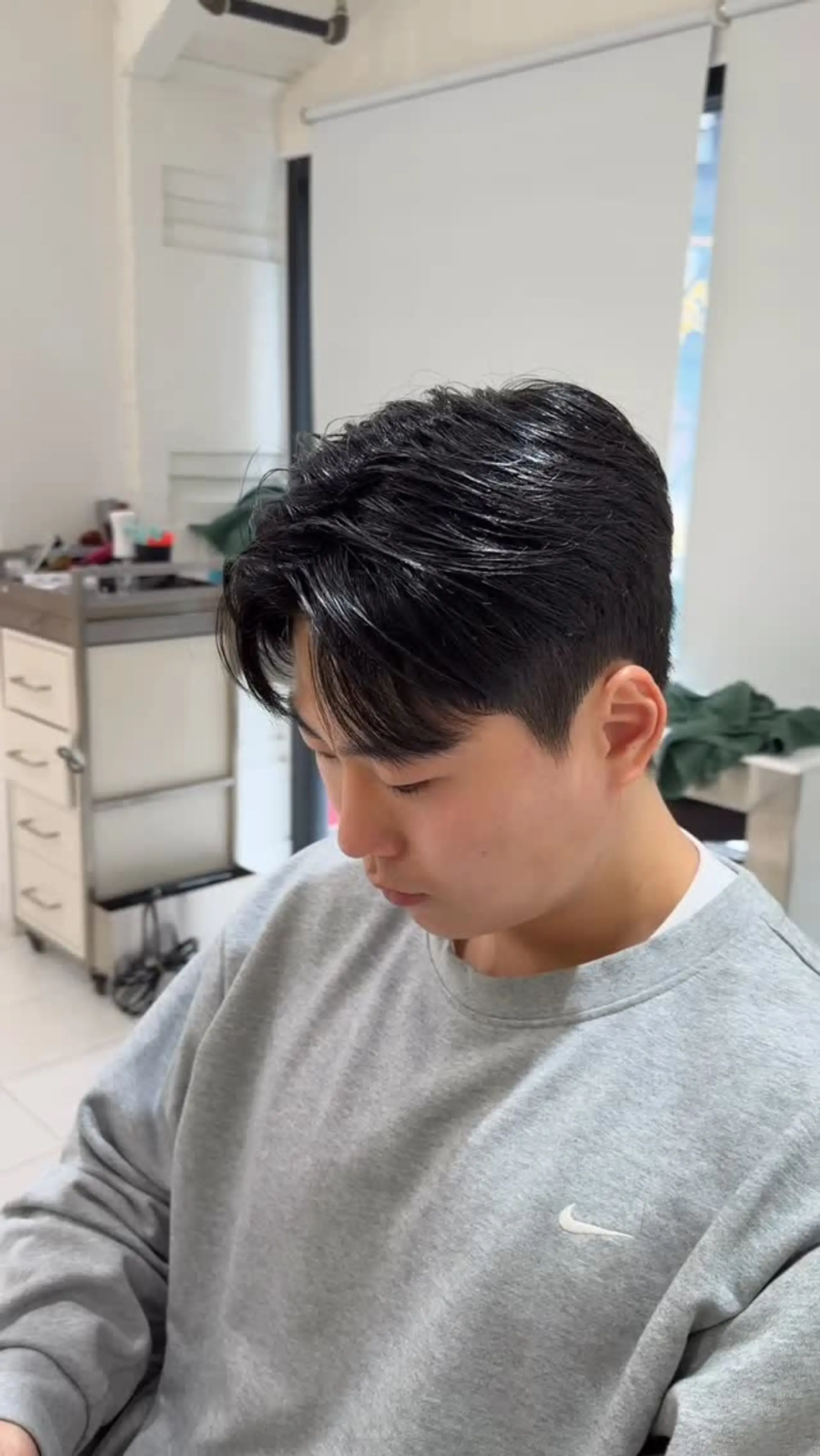 A Korean two-block haircut with short tapered sides and a softly textured, parted fringe with subtle natural wave. 1