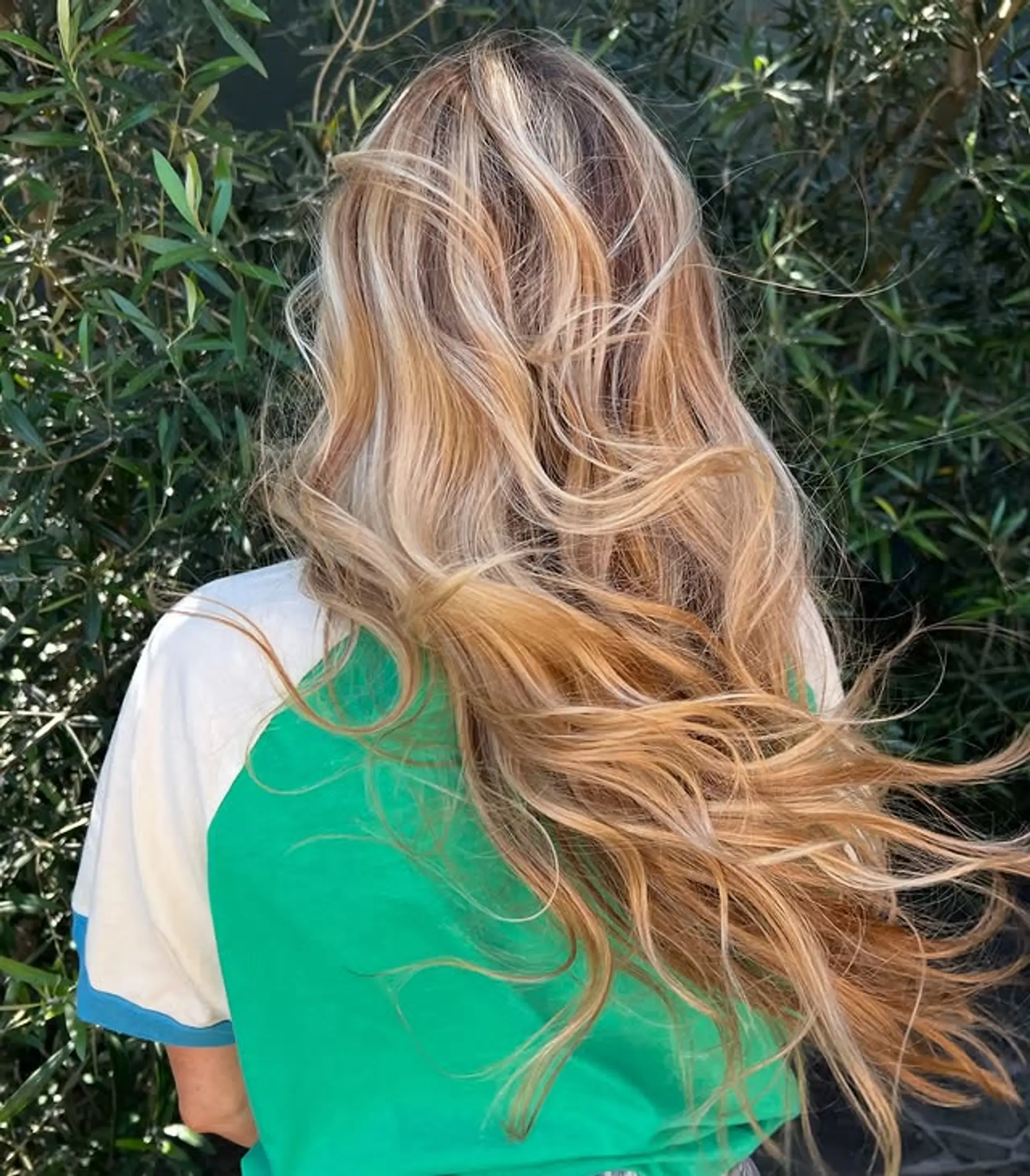 A long, wavy hairstyle with golden blonde balayage highlights. 1