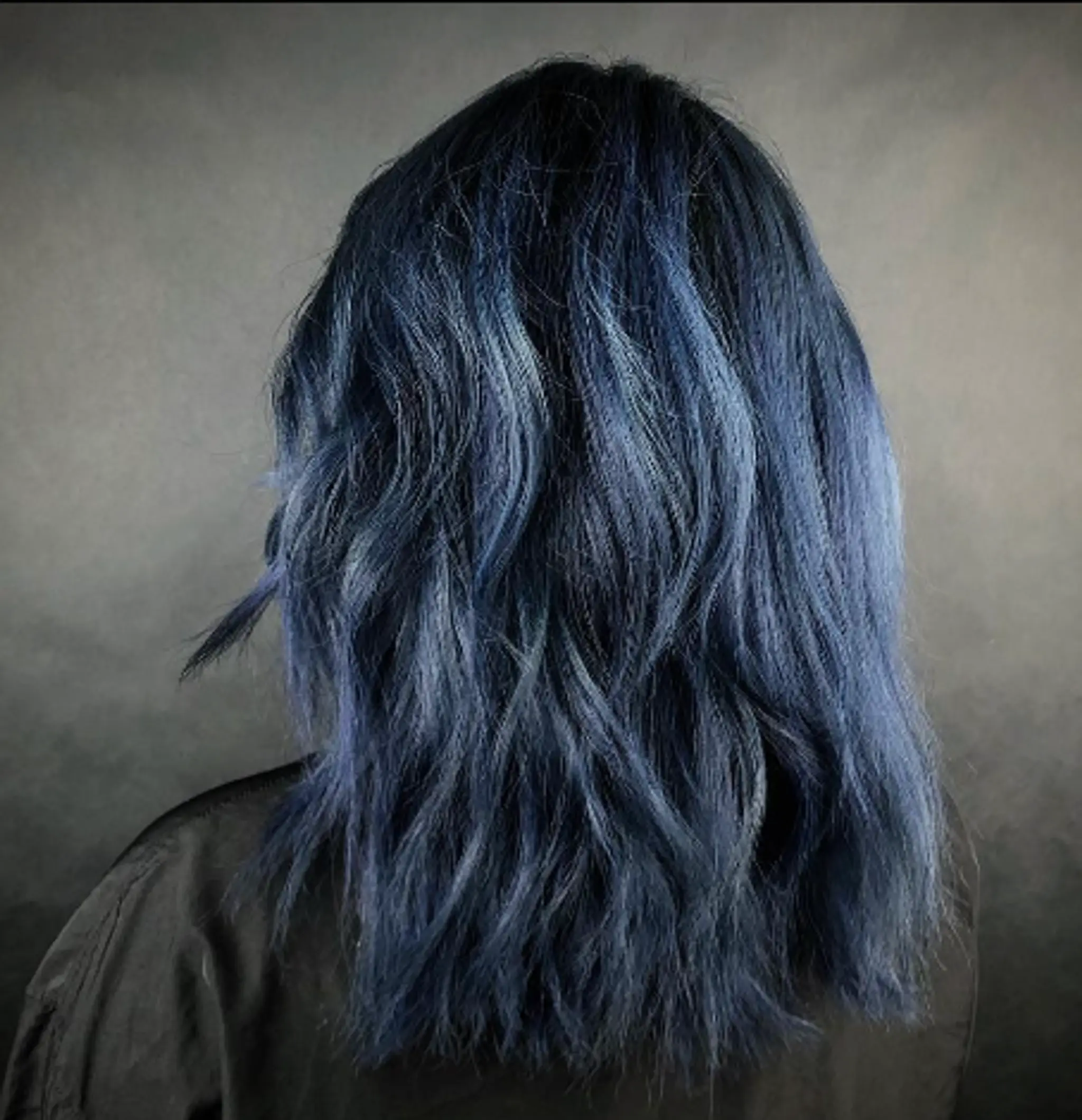This medium-length hairstyle features a striking dark blue to light blue gradient with wavy texture and luminous shine.