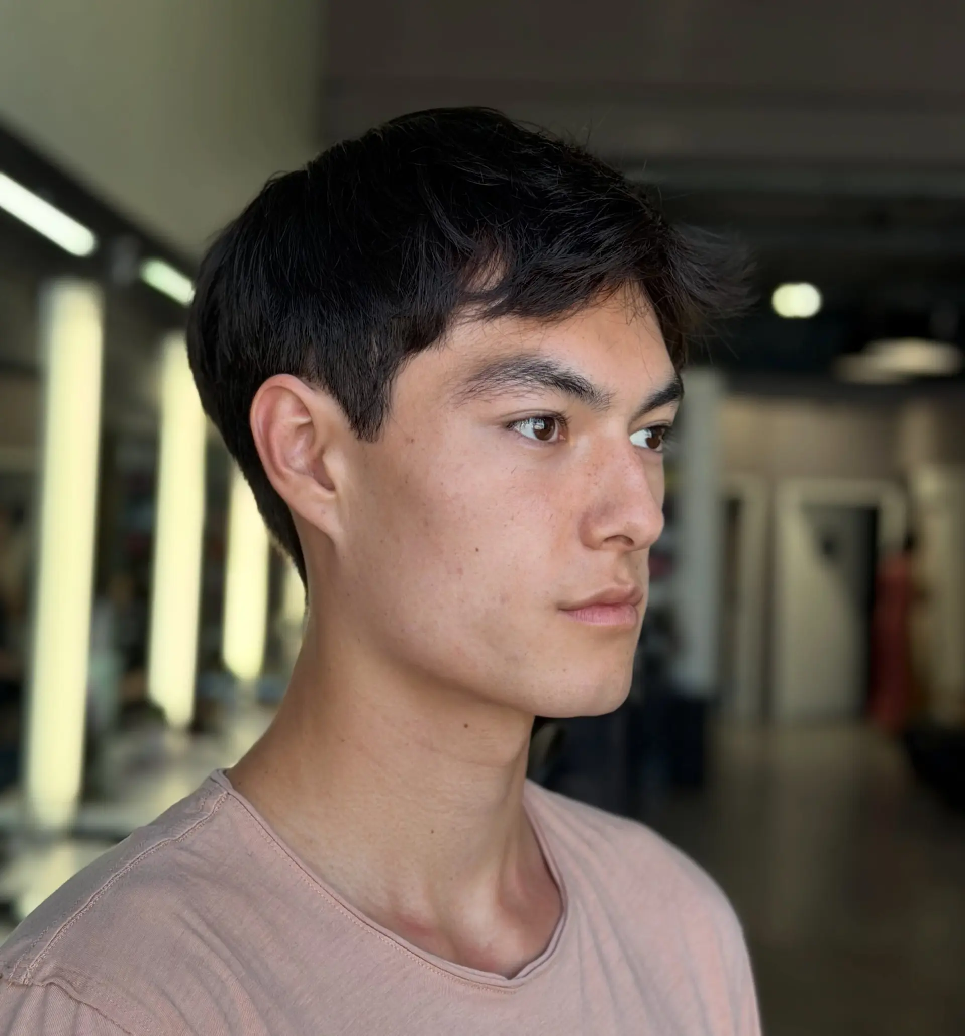 A modern short men's cut featuring a textured top with natural fringe and tapered sides. 1