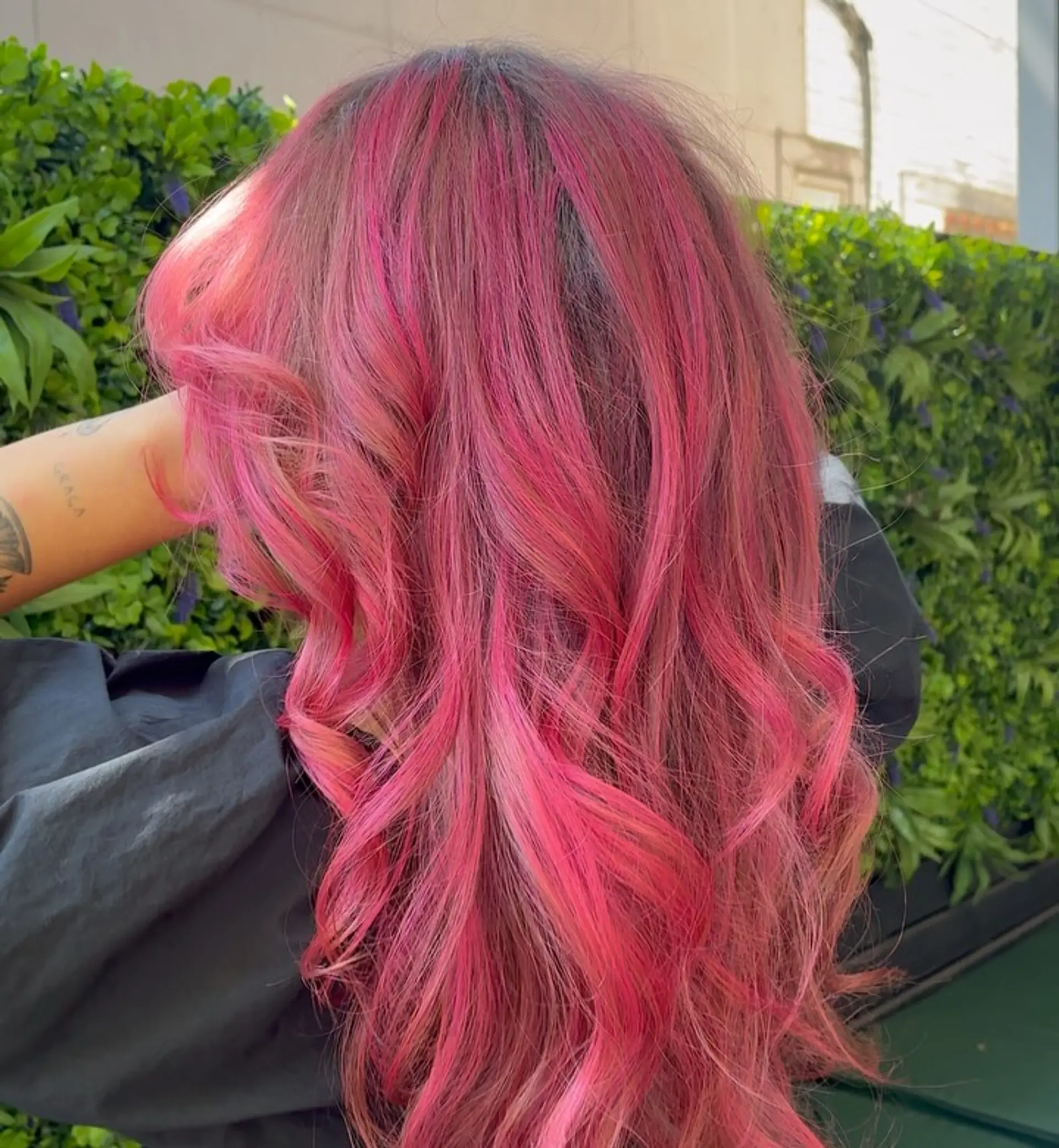 Long, vivid hot pink hair styled in soft, cascading textured waves. 1