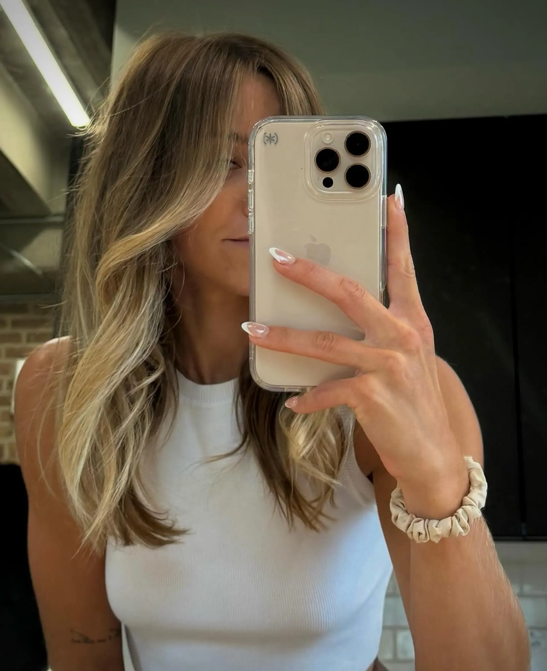 Long, flowing hair styled with soft, natural-looking beach waves and subtle, face-framing layers. The look is completed with stylish curtain bangs that sweep gently to the sides, enhancing the overall relaxed and chic aesthetic. 1