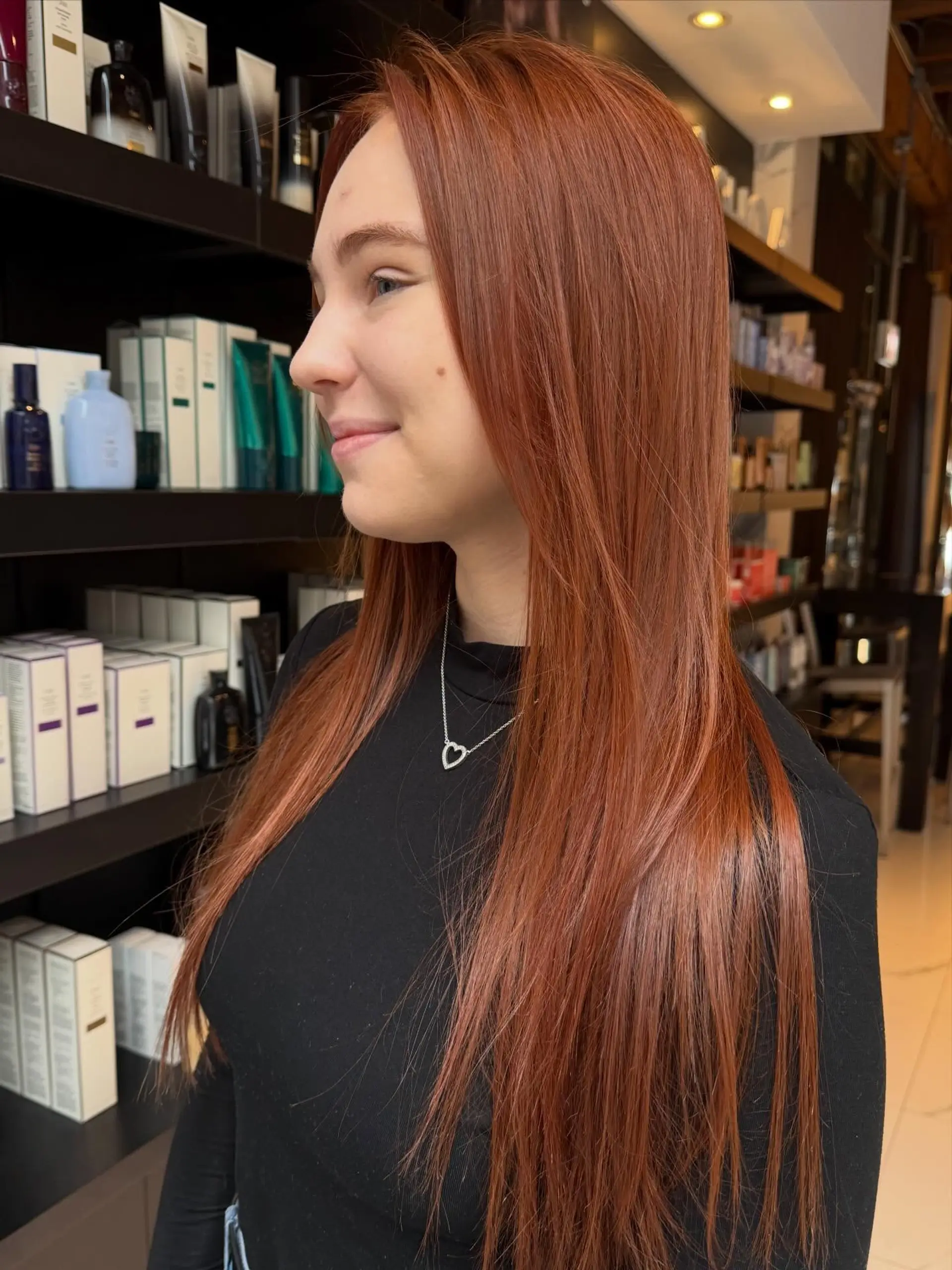 A sleek, long straight hairstyle dyed in a rich and radiant warm copper tone. 1