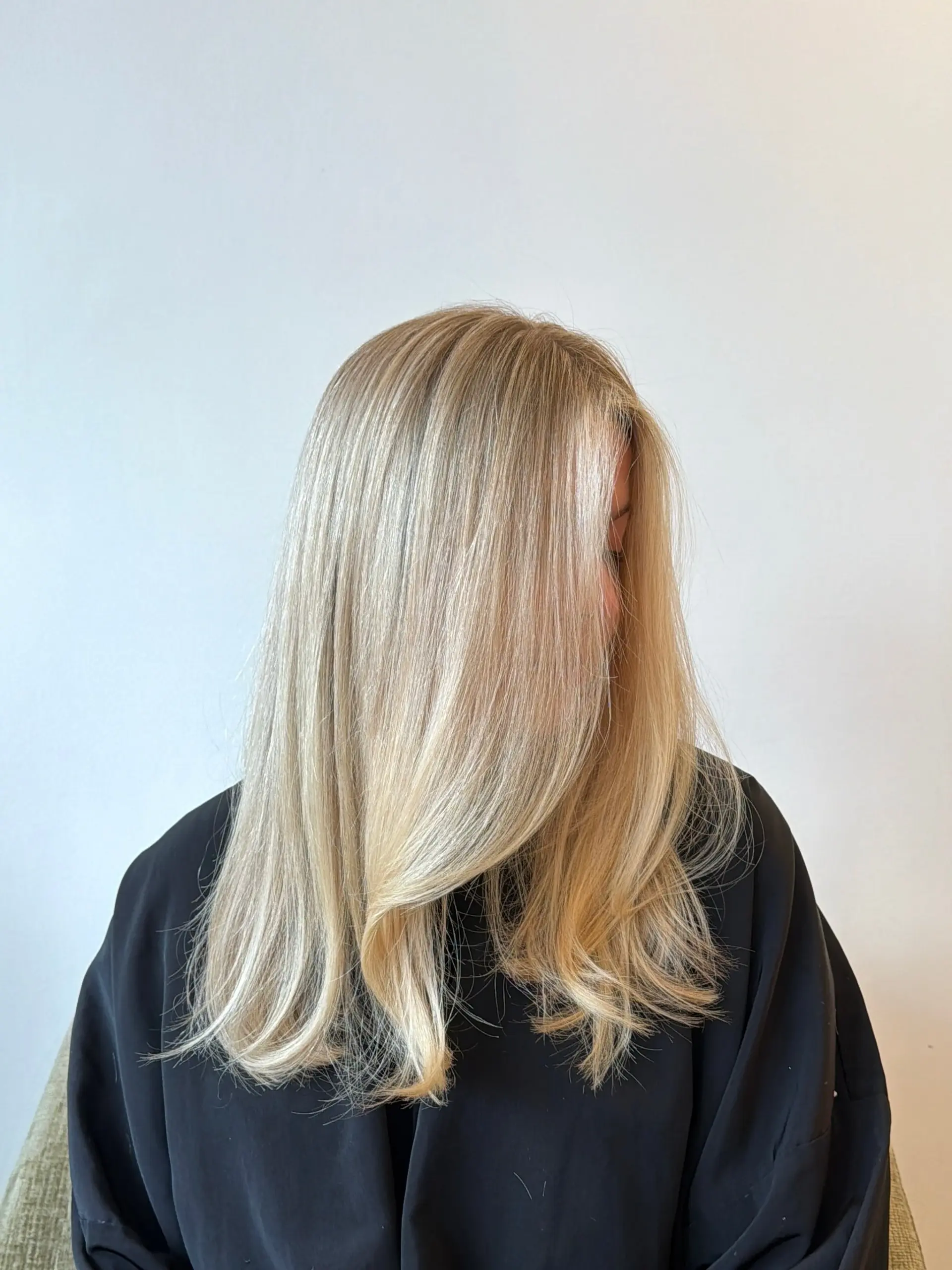 Smooth, bright blonde hair styled with a soft rounded blowout and layered face-framing sections. 1