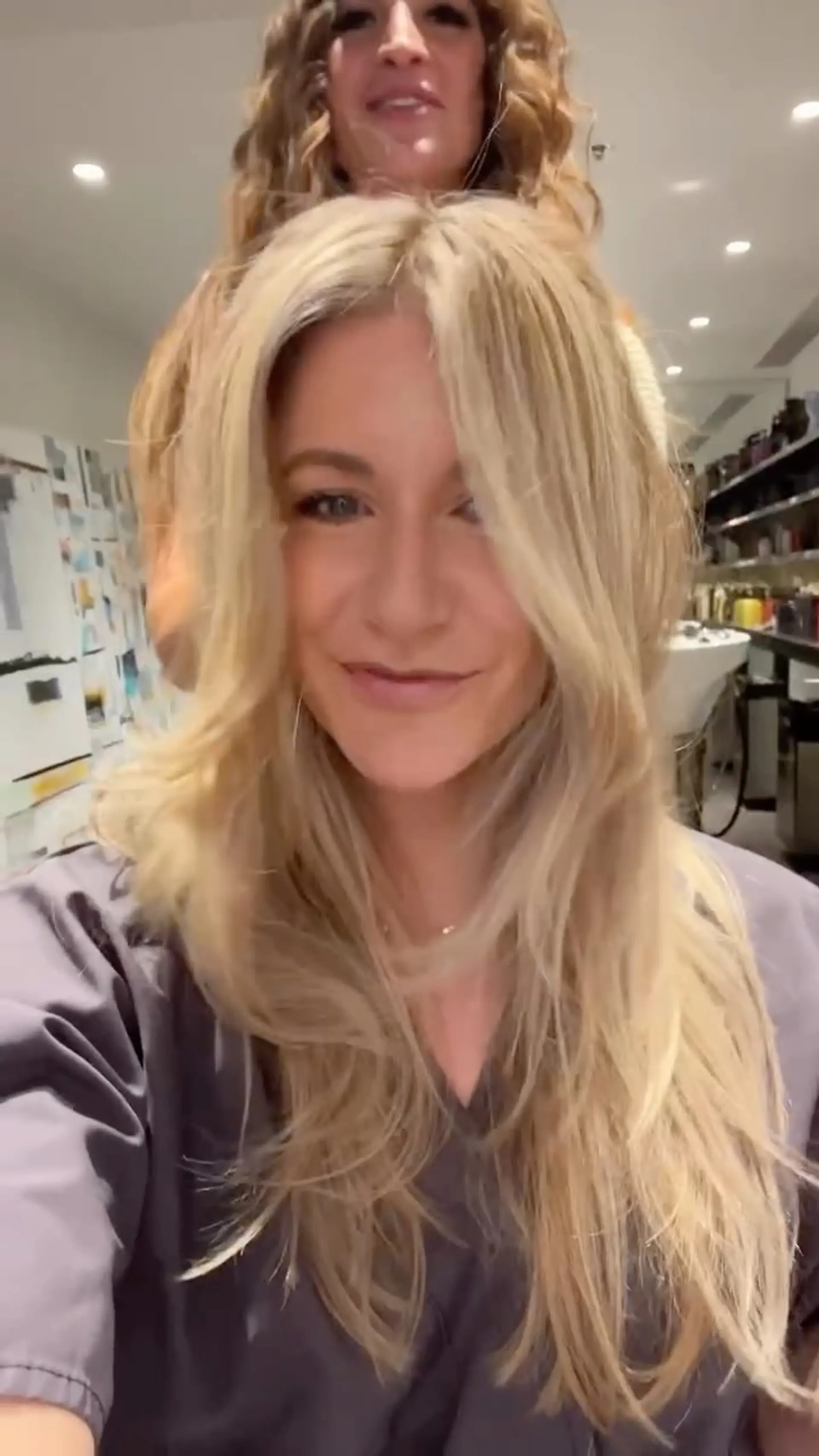 Long blonde hair cut with face-framing curtain bangs and textured layers, styled with soft volume and movement. 1