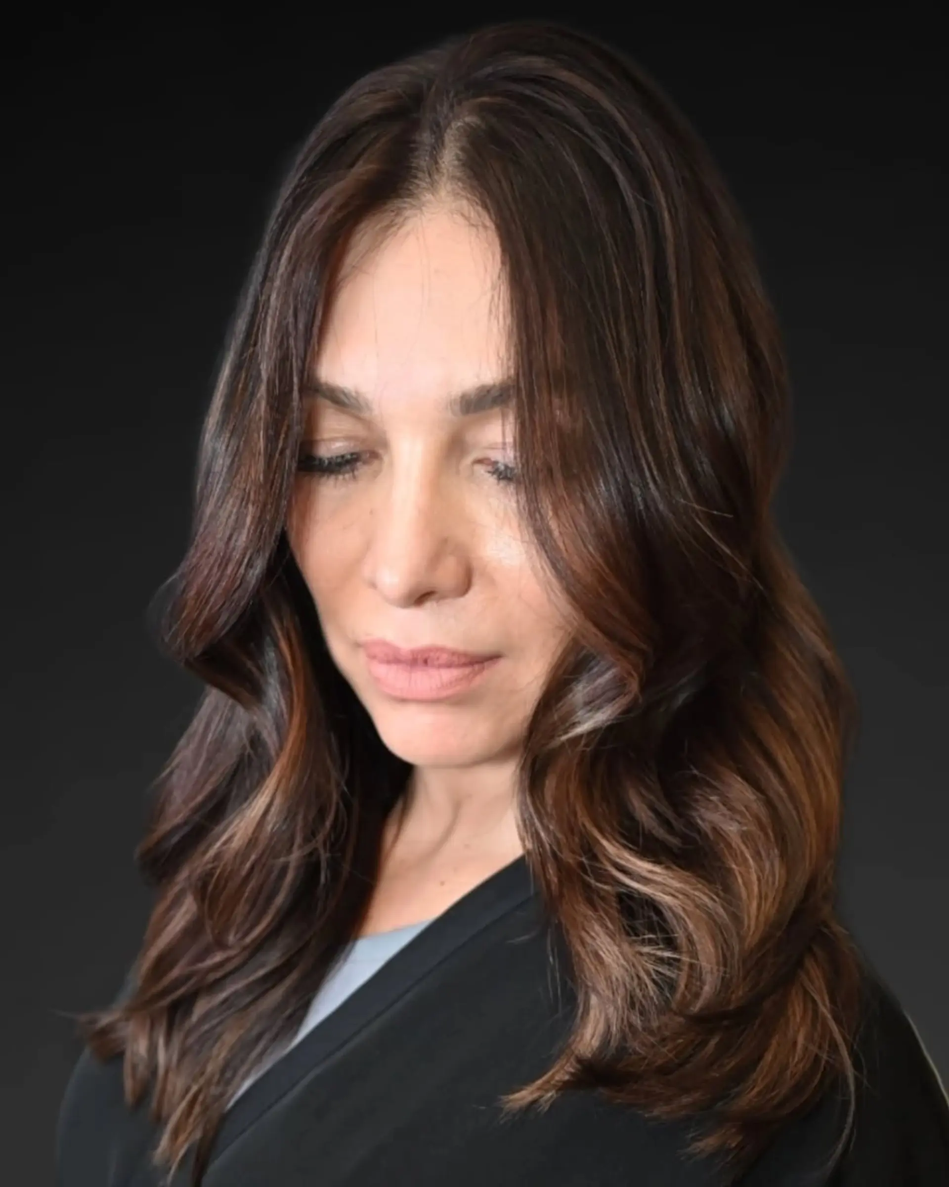 Long dark brown hair styled with soft, loose waves and subtle face-framing dimensional highlights. 1