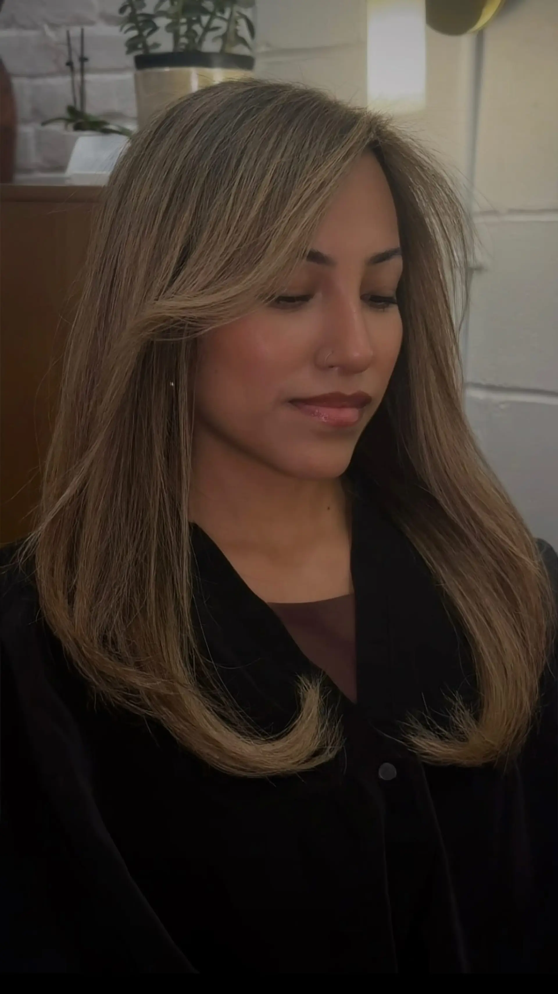 A soft dimensional bronde color cut with face-framing layers and styled into a sleek blowout. 1