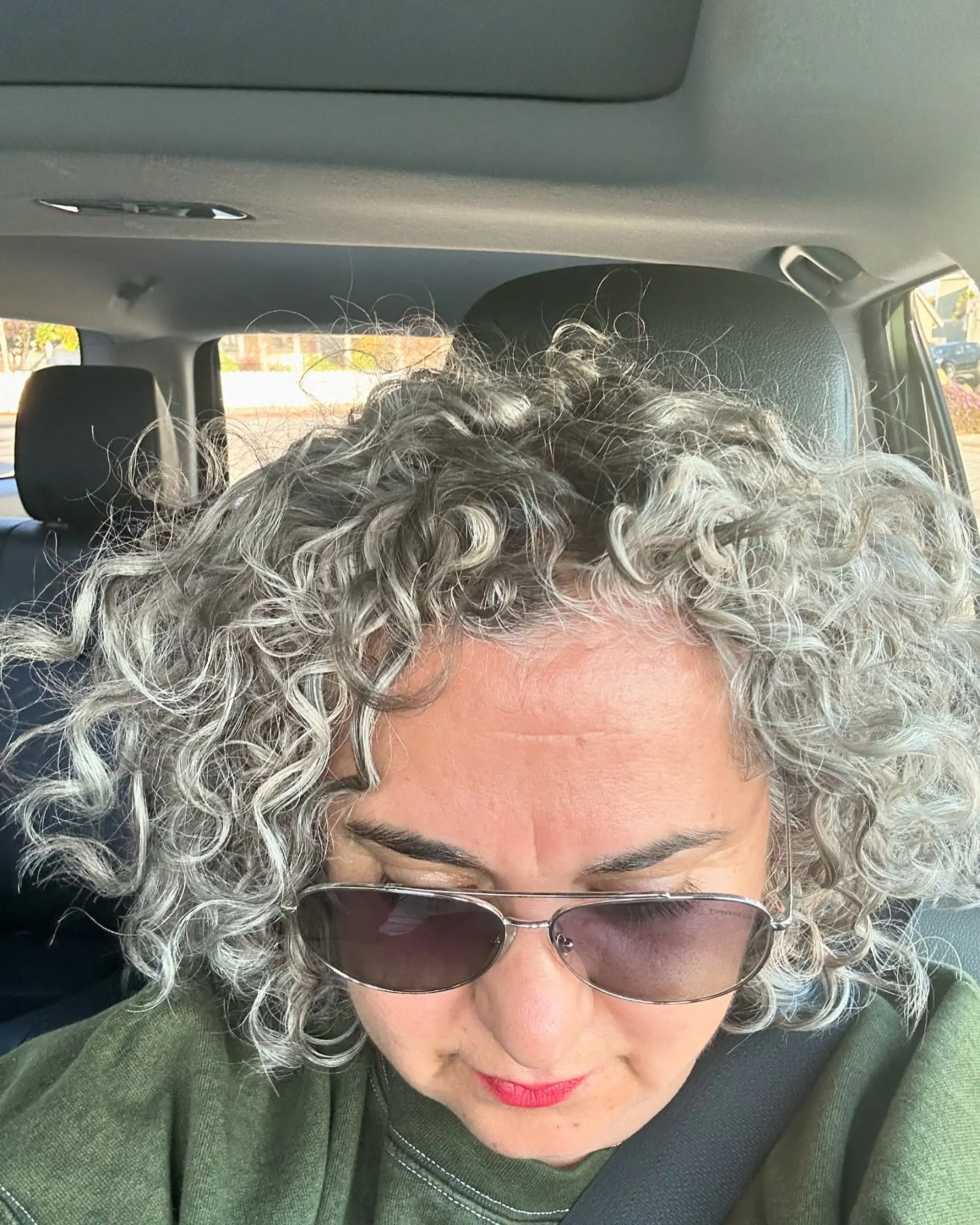 Naturally curly short cut featuring seamless silver and grey blending with platinum highlights. 1