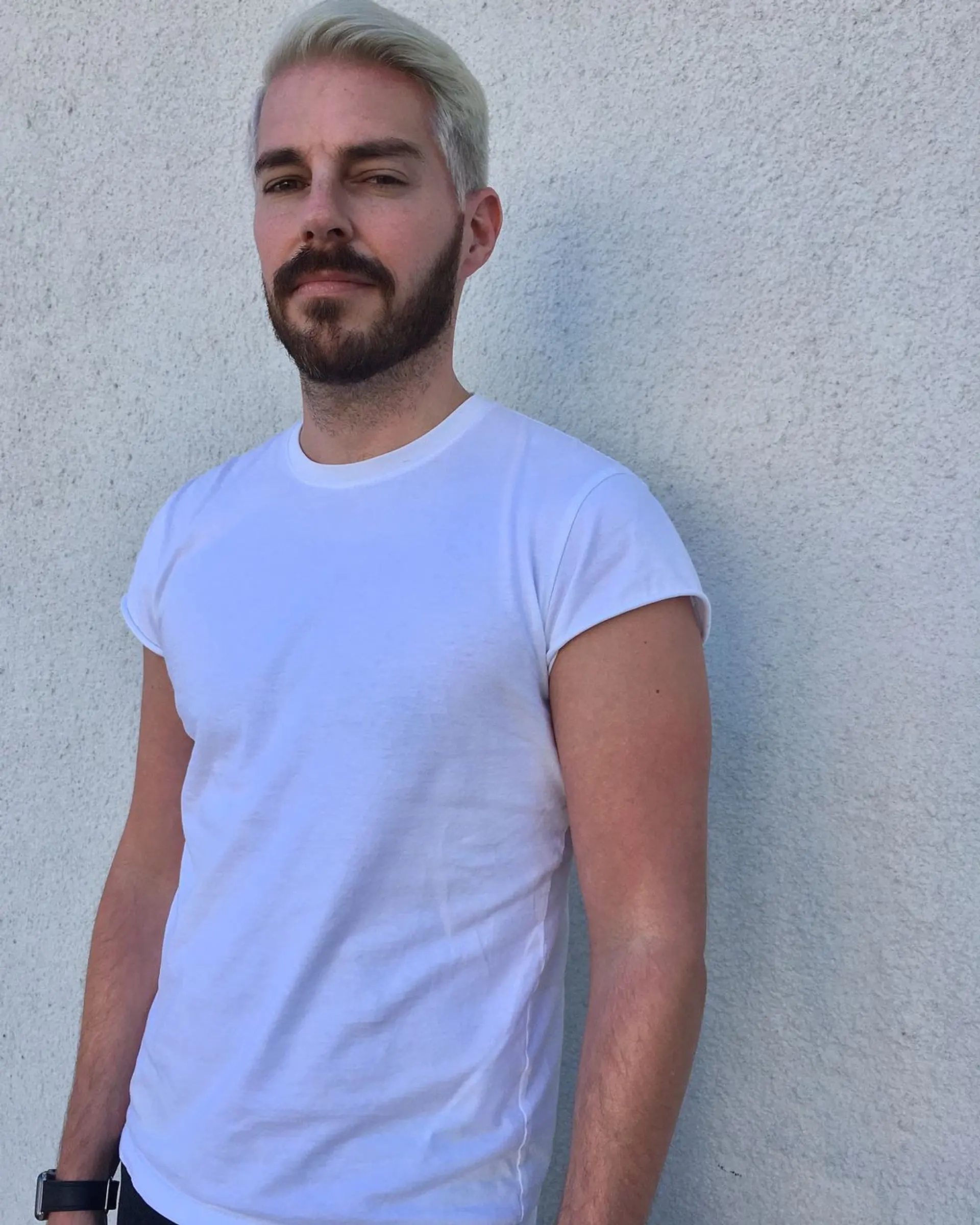 The style features a neat, side-swept quiff in bold platinum blonde, with tapered sides and a textured top for a clean, contemporary look. 1