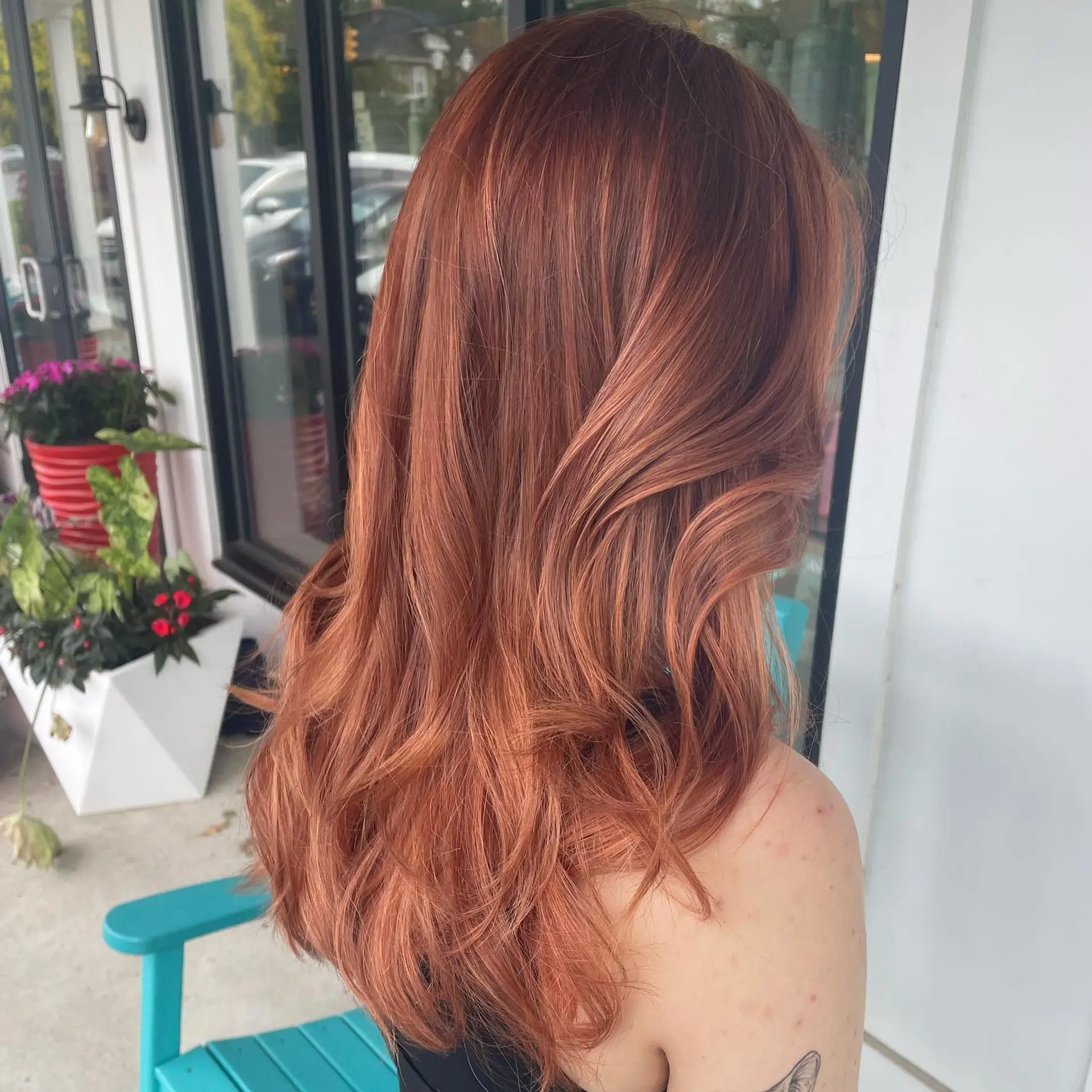 Long peachy rose-gold hair styled with glossy, flowing waves. 1