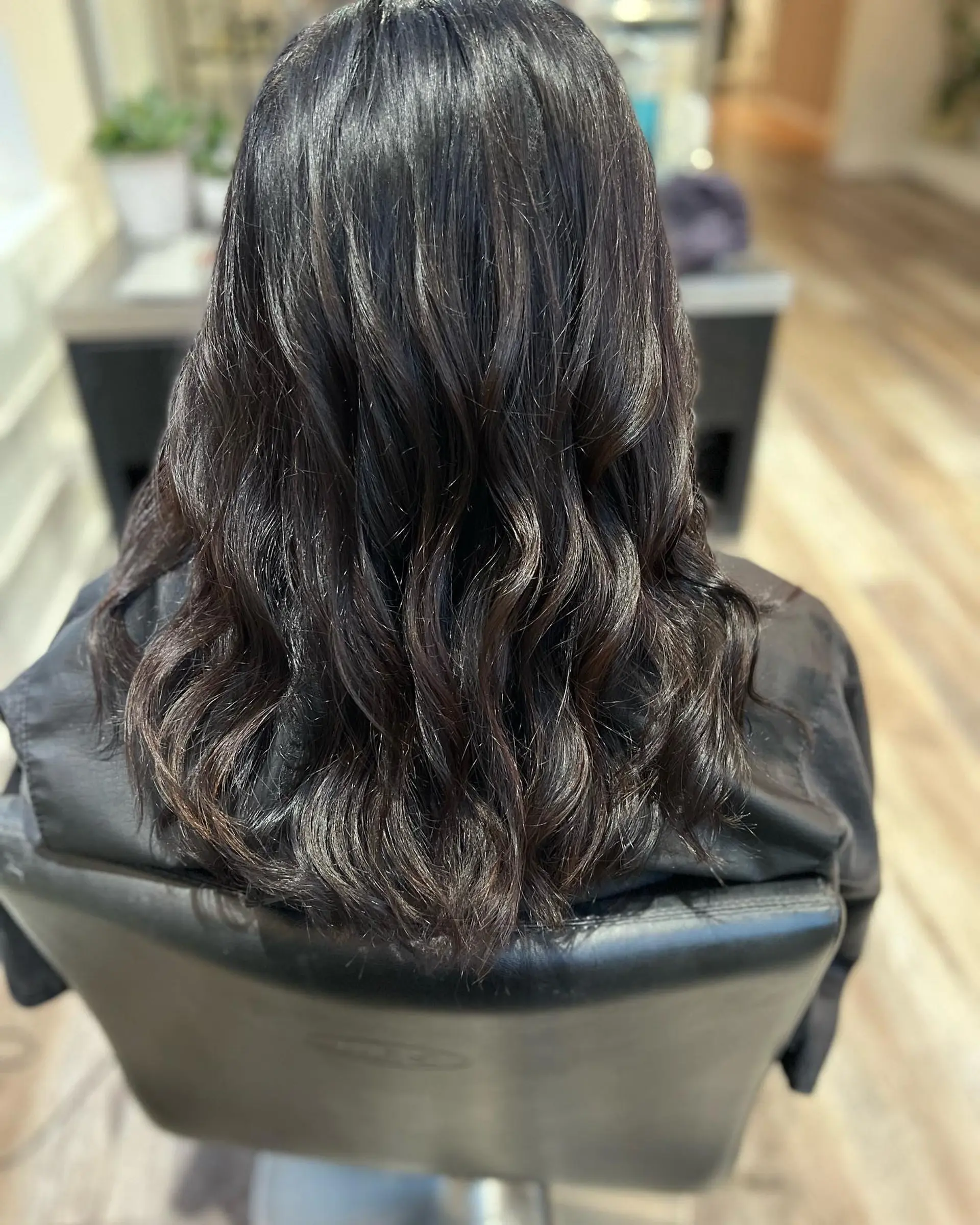 Medium-length dark brunette hair styled into shiny, soft loose waves. 1