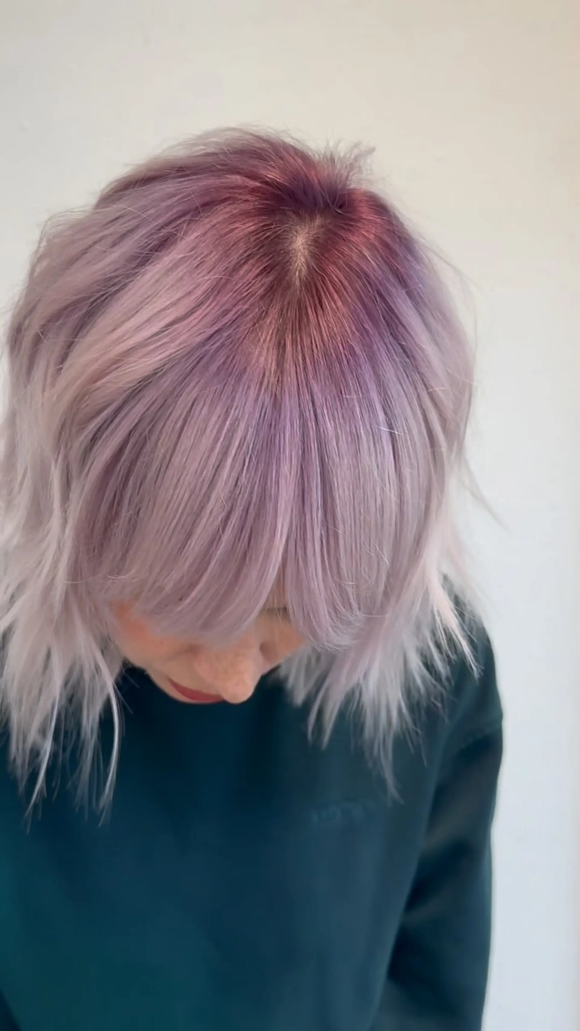 A textured short shag haircut featuring full face-framing bangs and a frosted lilac-berry pastel tone blended from a deep magenta shadow root. 1