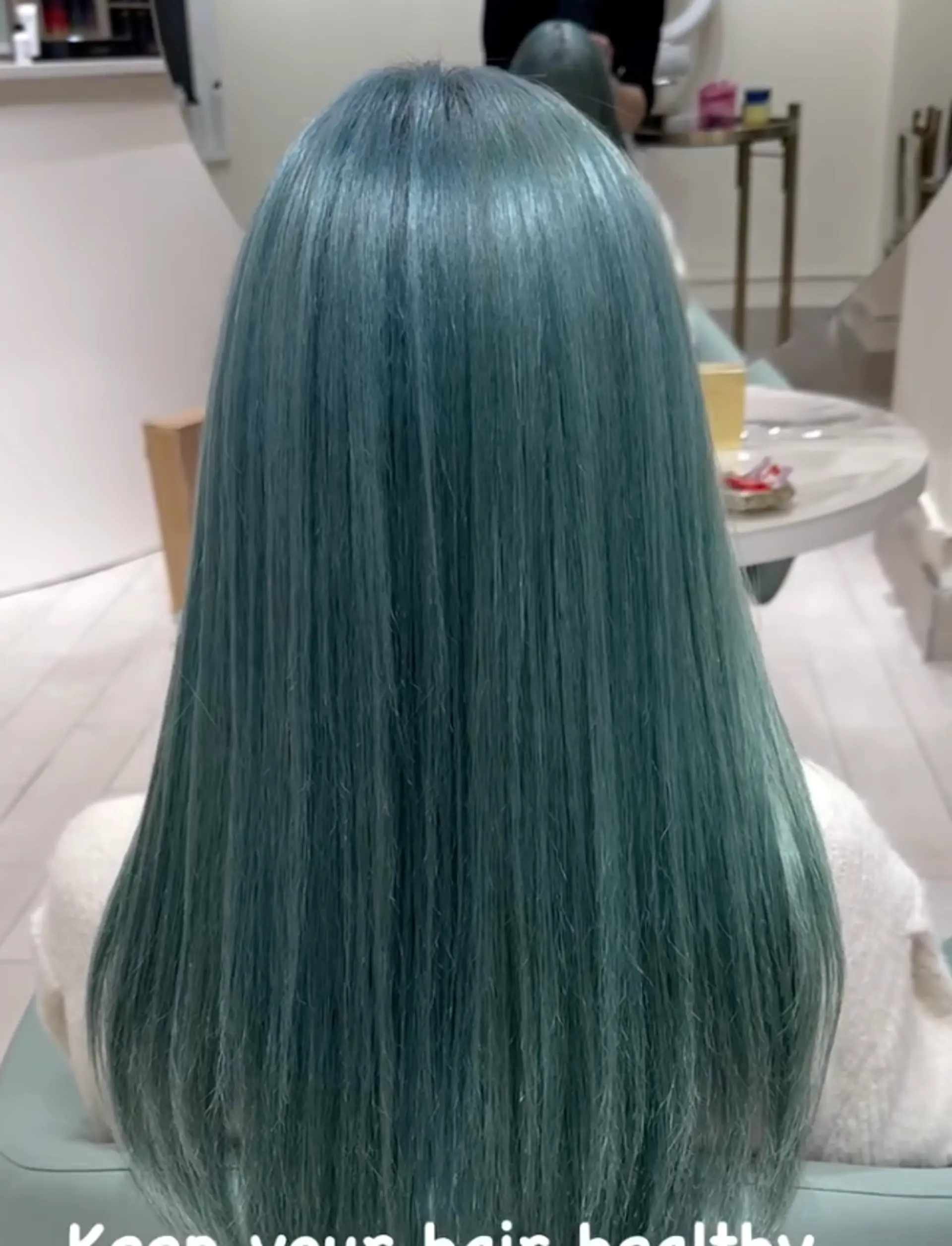 A long, straight, and sleek hairstyle with a vibrant teal color, creating a smooth and polished look that cascades down the back. 2