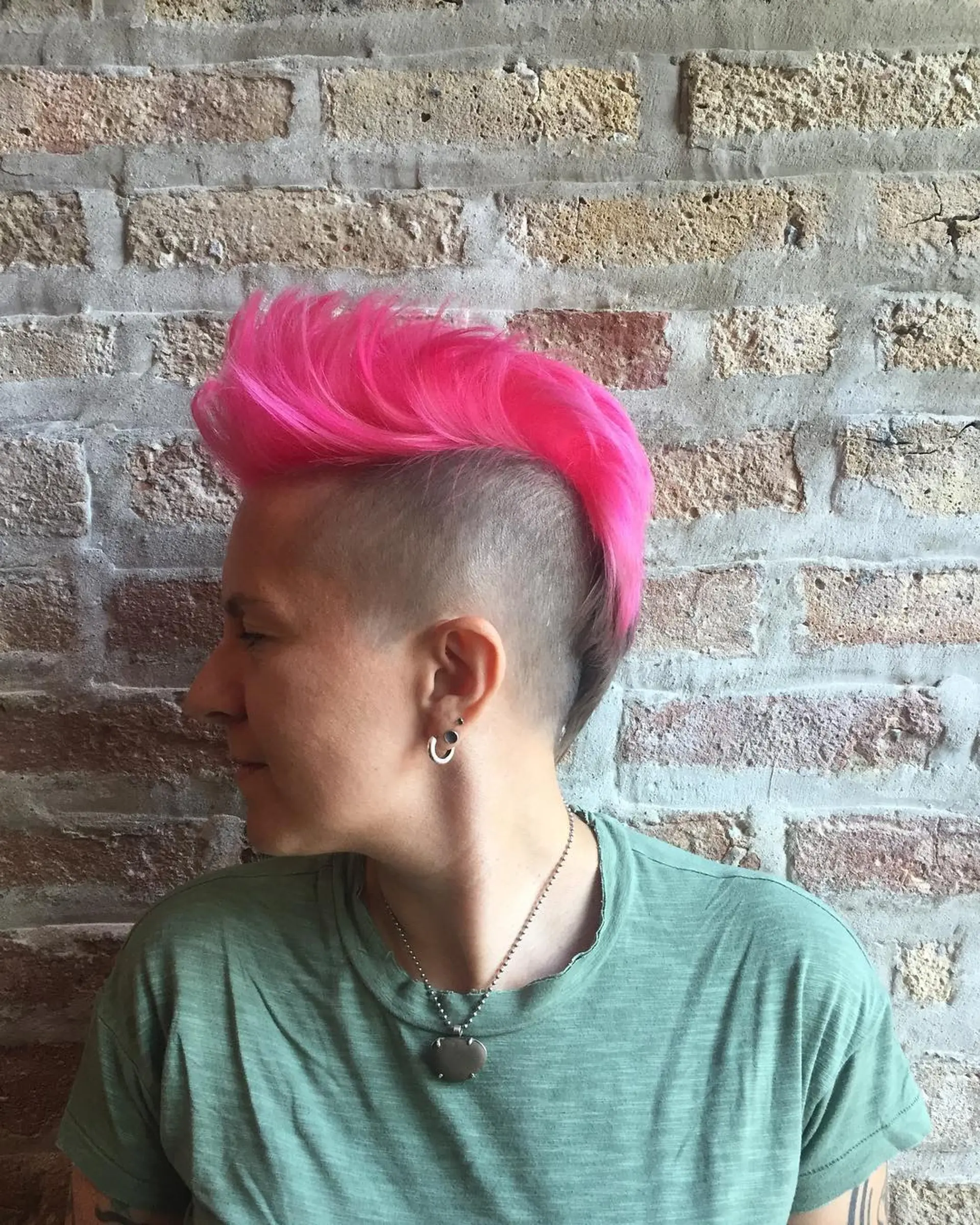 A short mohawk with faded sides, styled in a vibrant electric pink. 1