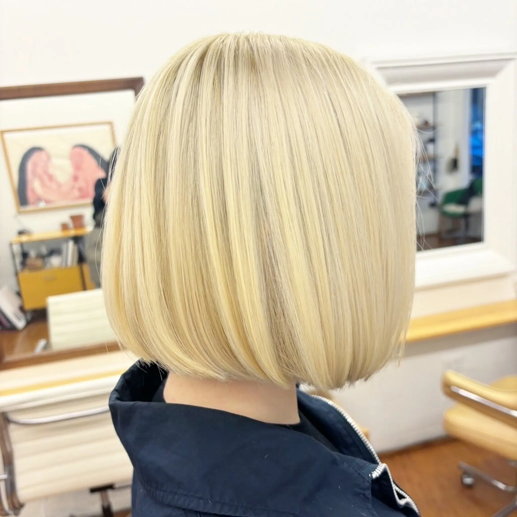 A short, blonde blunt bob with straight, chin-length hair and a smooth, silky texture. Haircut and color by @kotomiacacio__hair 