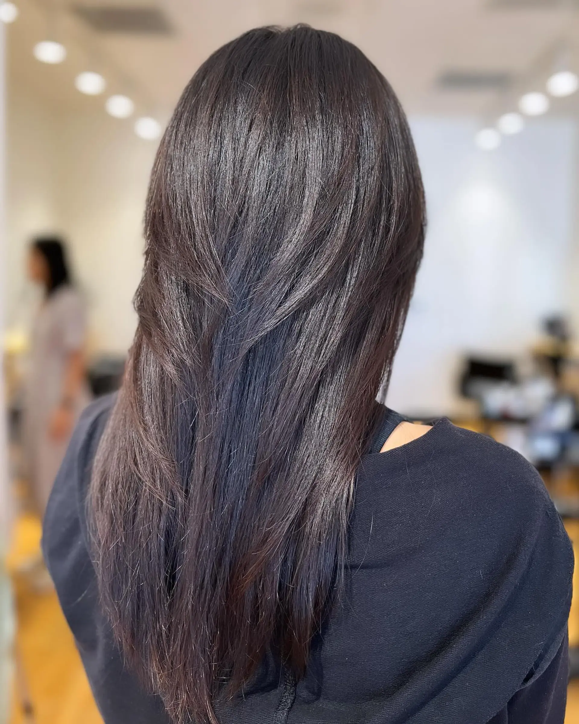 Long straight dark hair cut with smooth, cascading textured layers and a sleek finish. 1