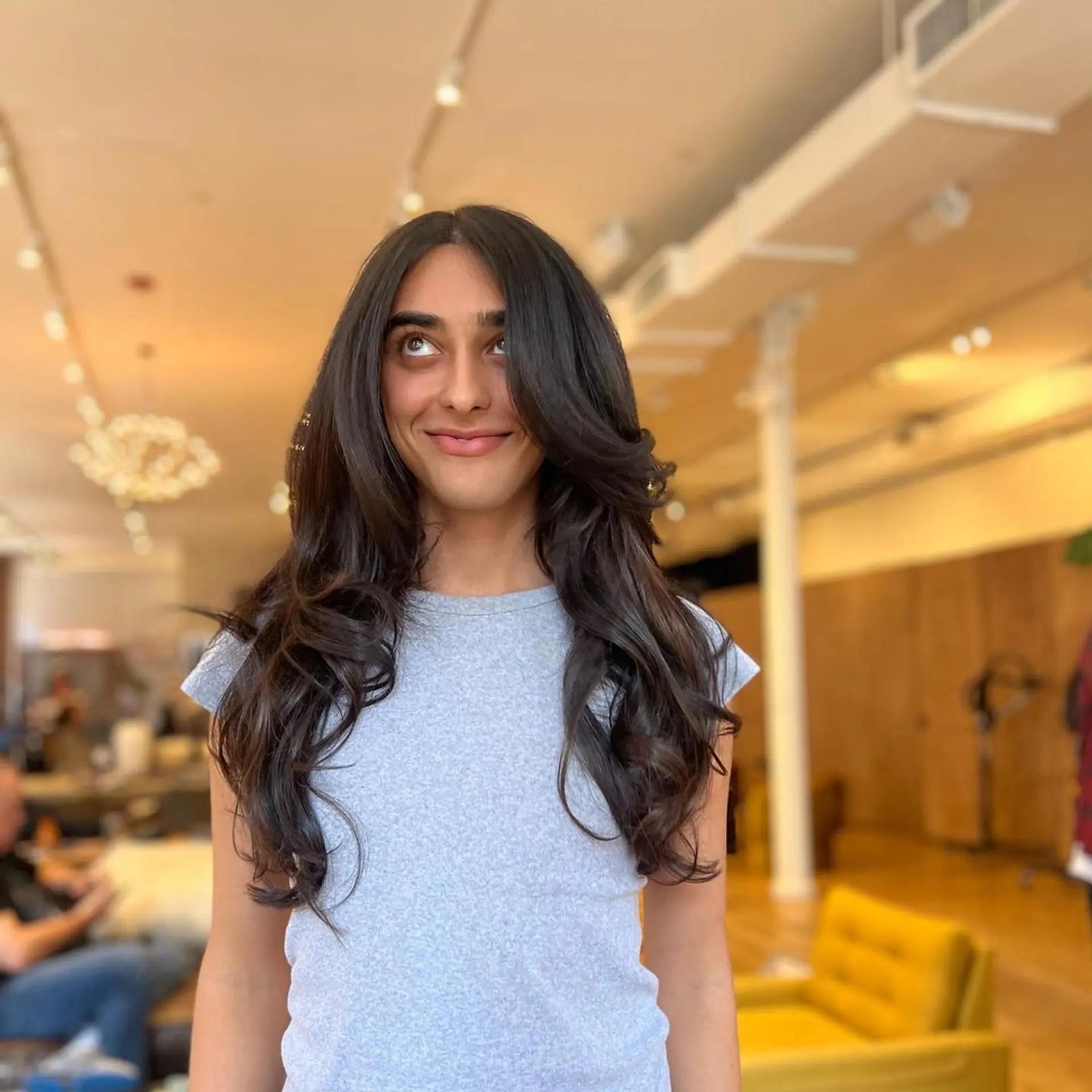 Long, dark brown hair styled in soft, voluminous waves with a middle parting and shiny finish. Hand tied wefts for volume and a bit of length 1