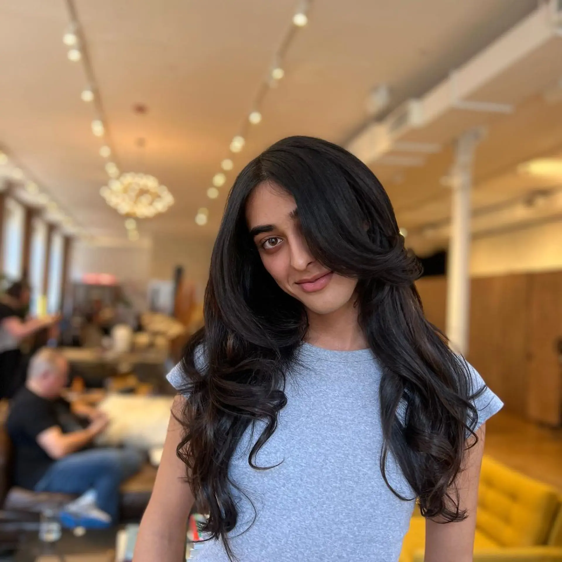 Long, dark brown hair styled in soft, voluminous waves with a middle parting and shiny finish. Hand tied wefts for volume and a bit of length 2