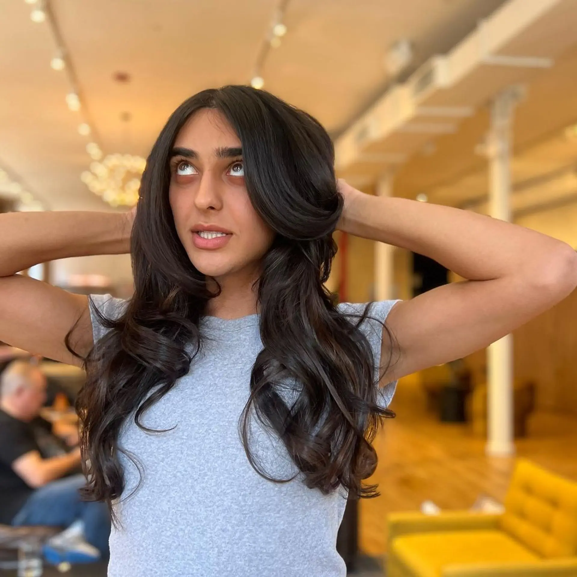 Long, dark brown hair styled in soft, voluminous waves with a middle parting and shiny finish. Hand tied wefts for volume and a bit of length 3