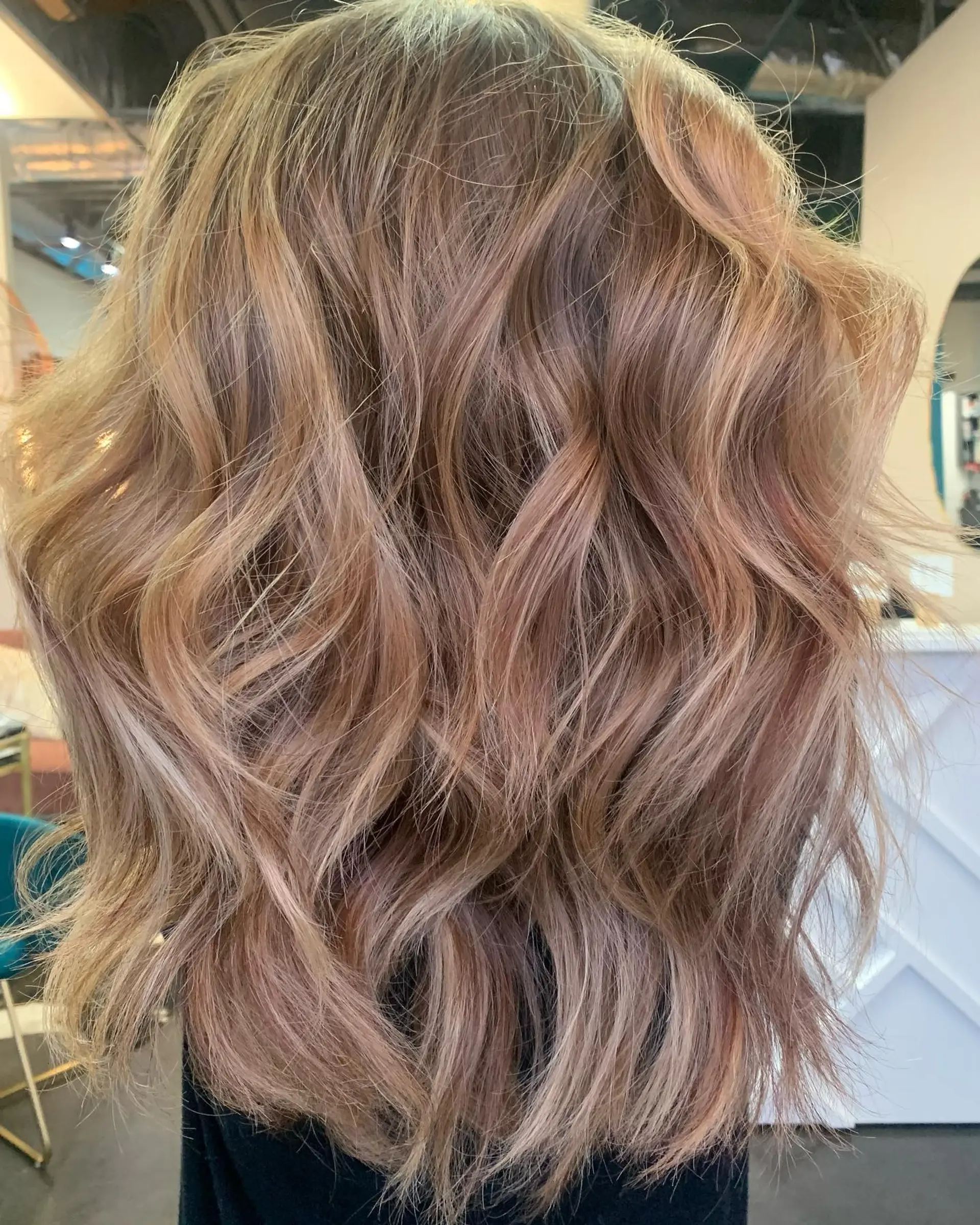 Medium-length layered cut styled in loose, tousled waves with multidimensional golden and copper balayage. 1