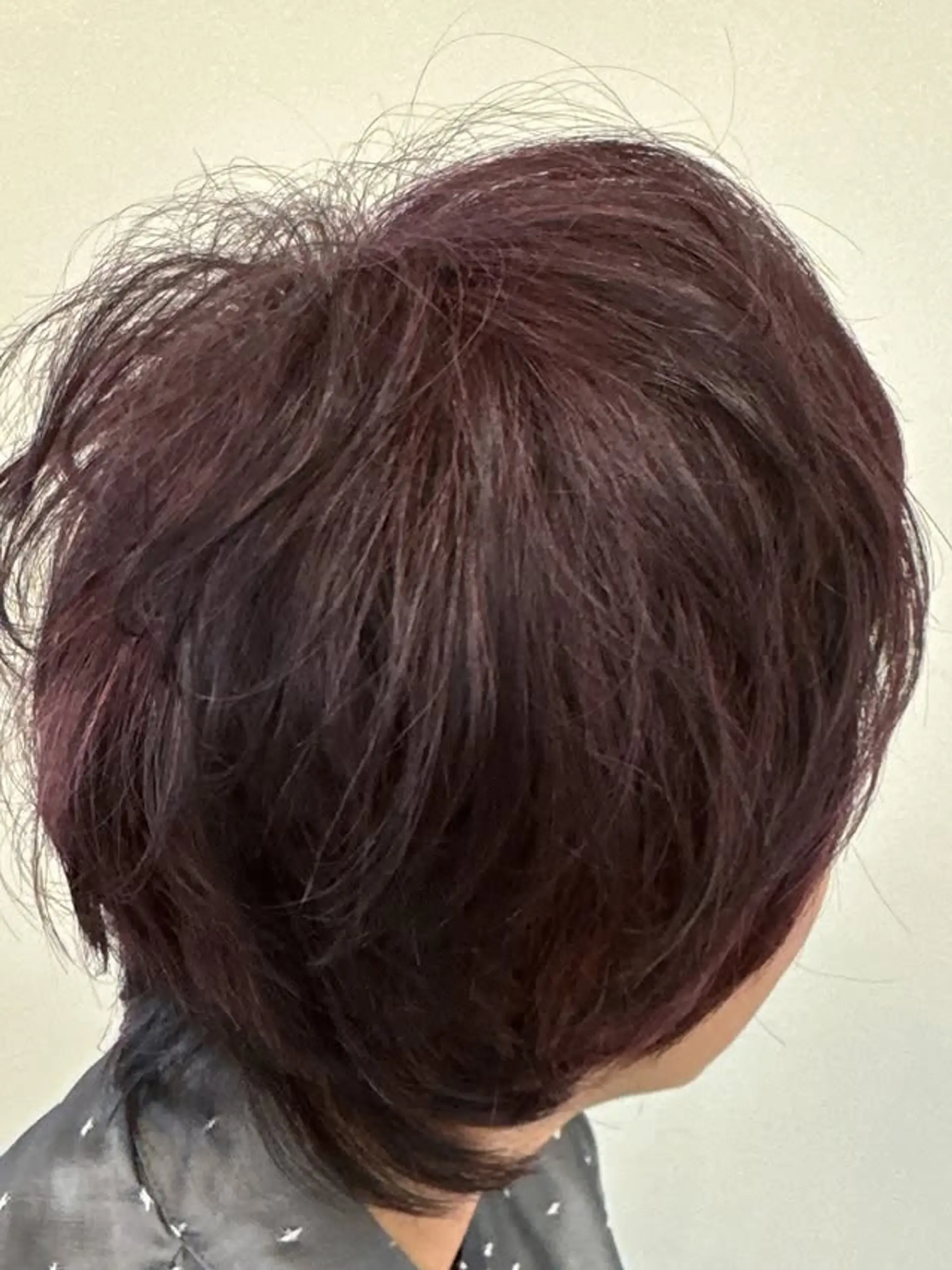 A short, textured bob with a burgundy color melt. 1