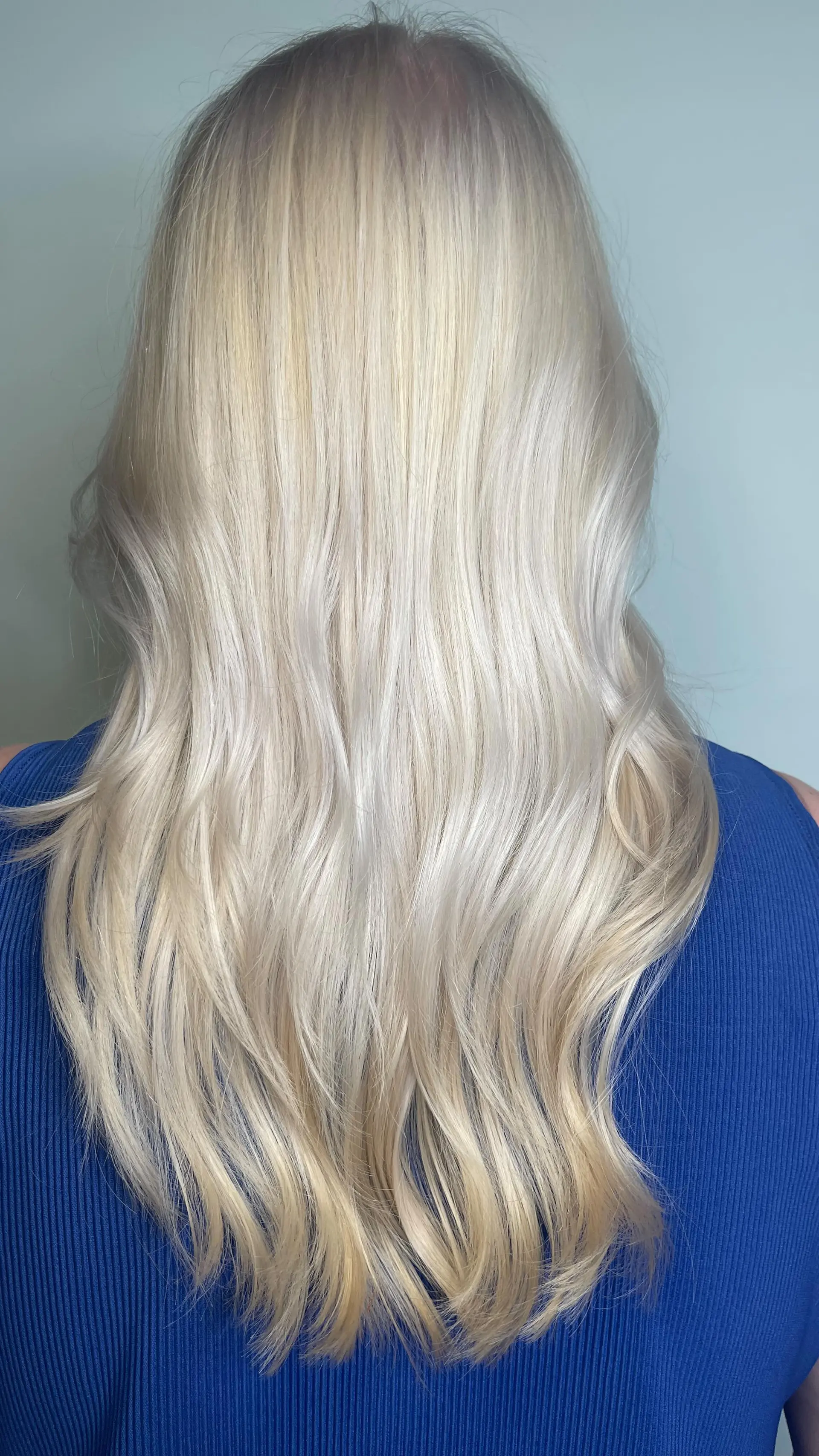 Long, seamless platinum blonde hair styled with soft, relaxed waves and a glossy finish. 1
