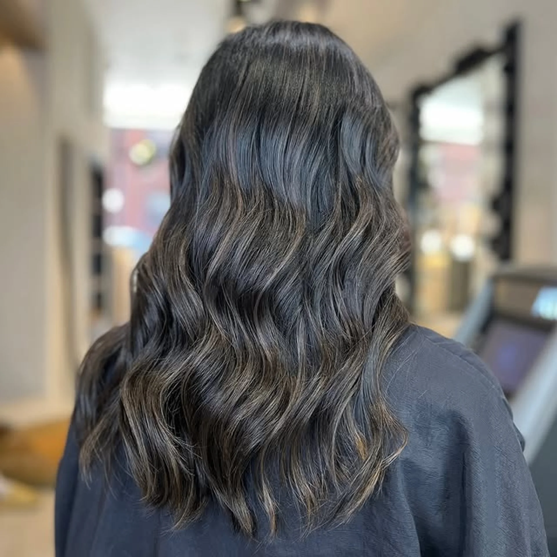 A woman with long, flowing wavy hair featuring a warm honey balayage, representing the 2026 'Amber Haze' hair color trend. - Preview 3