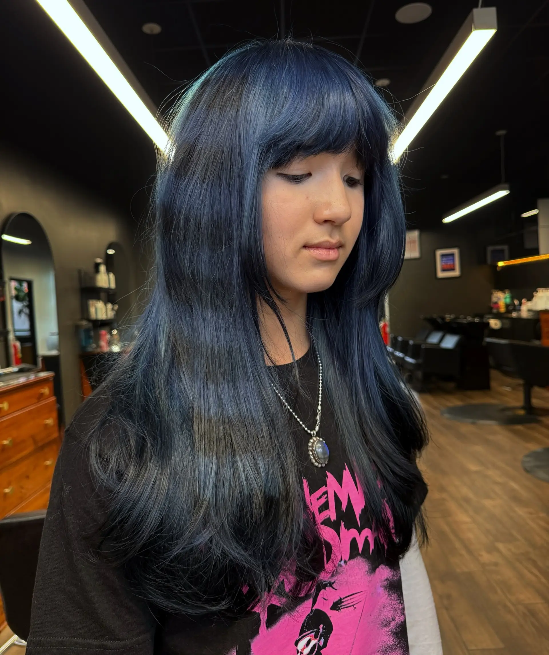 Long midnight denim blue hair with full forehead bangs and softly curved face-framing layers. 1