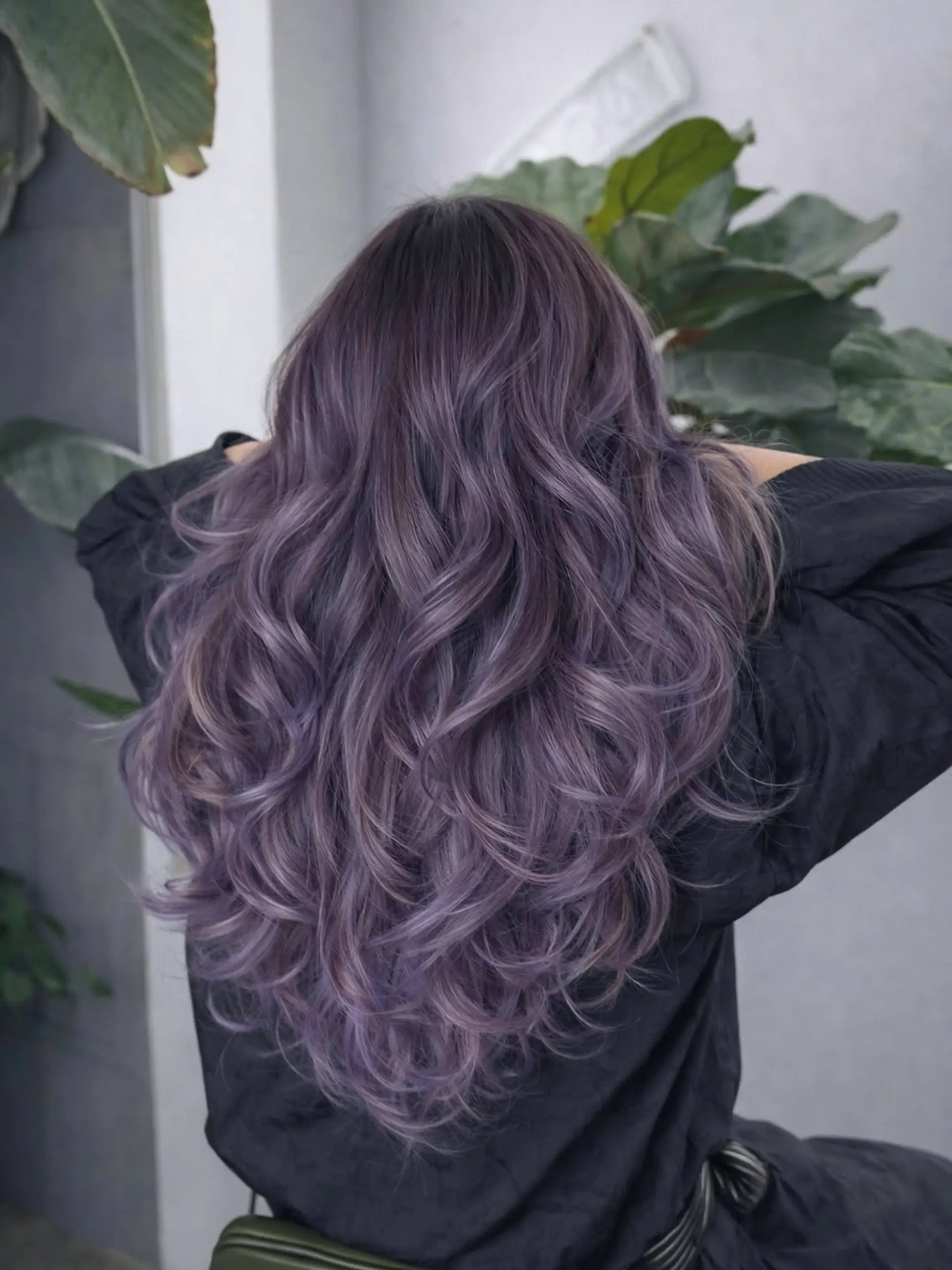 Long, layered hair styled in soft, loose waves with a dimensional lavender and ash-grey balayage color technique. 1
