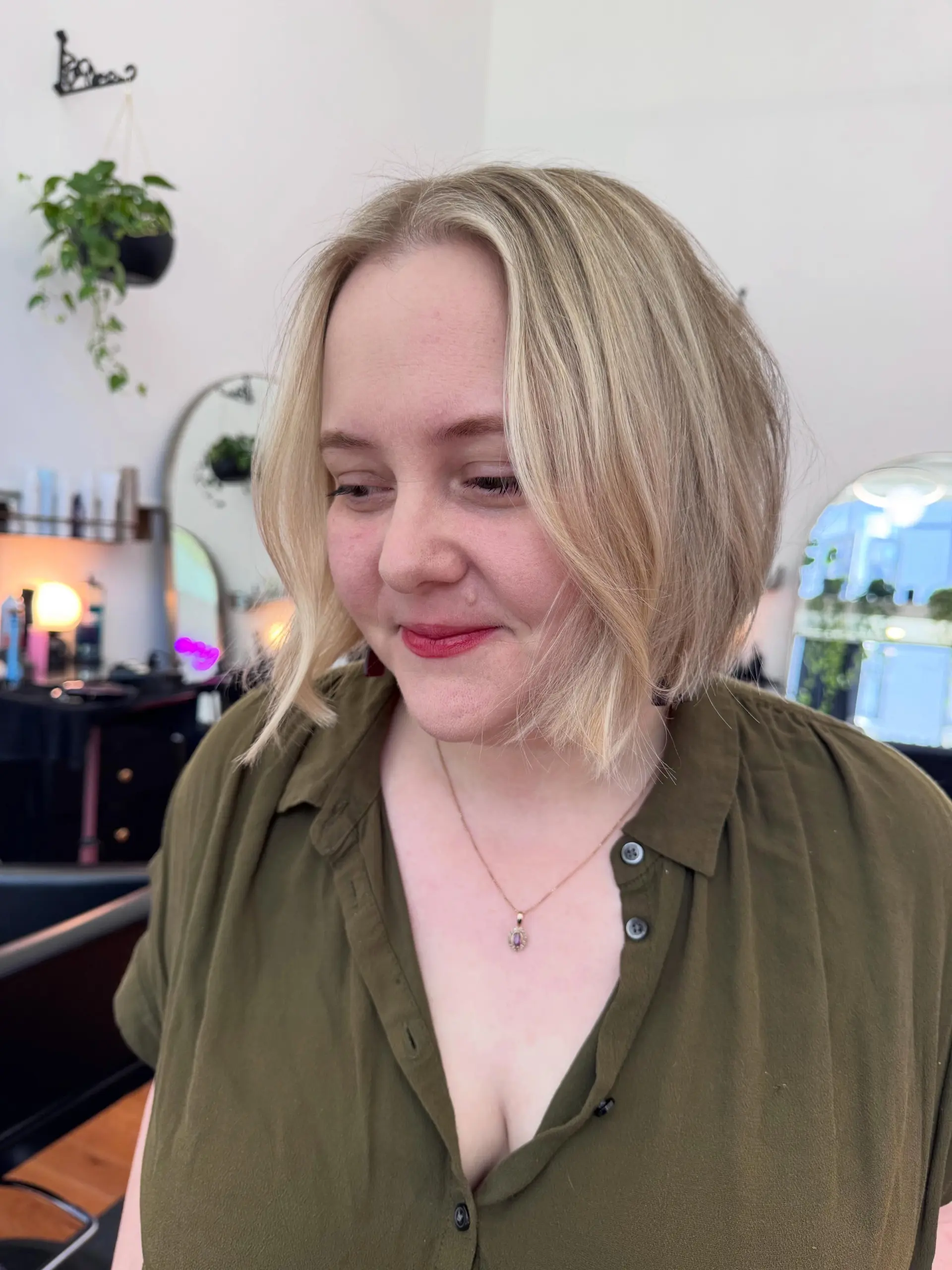 A textured chin-length blonde bob with a center part and soft, face-framing layers. 1