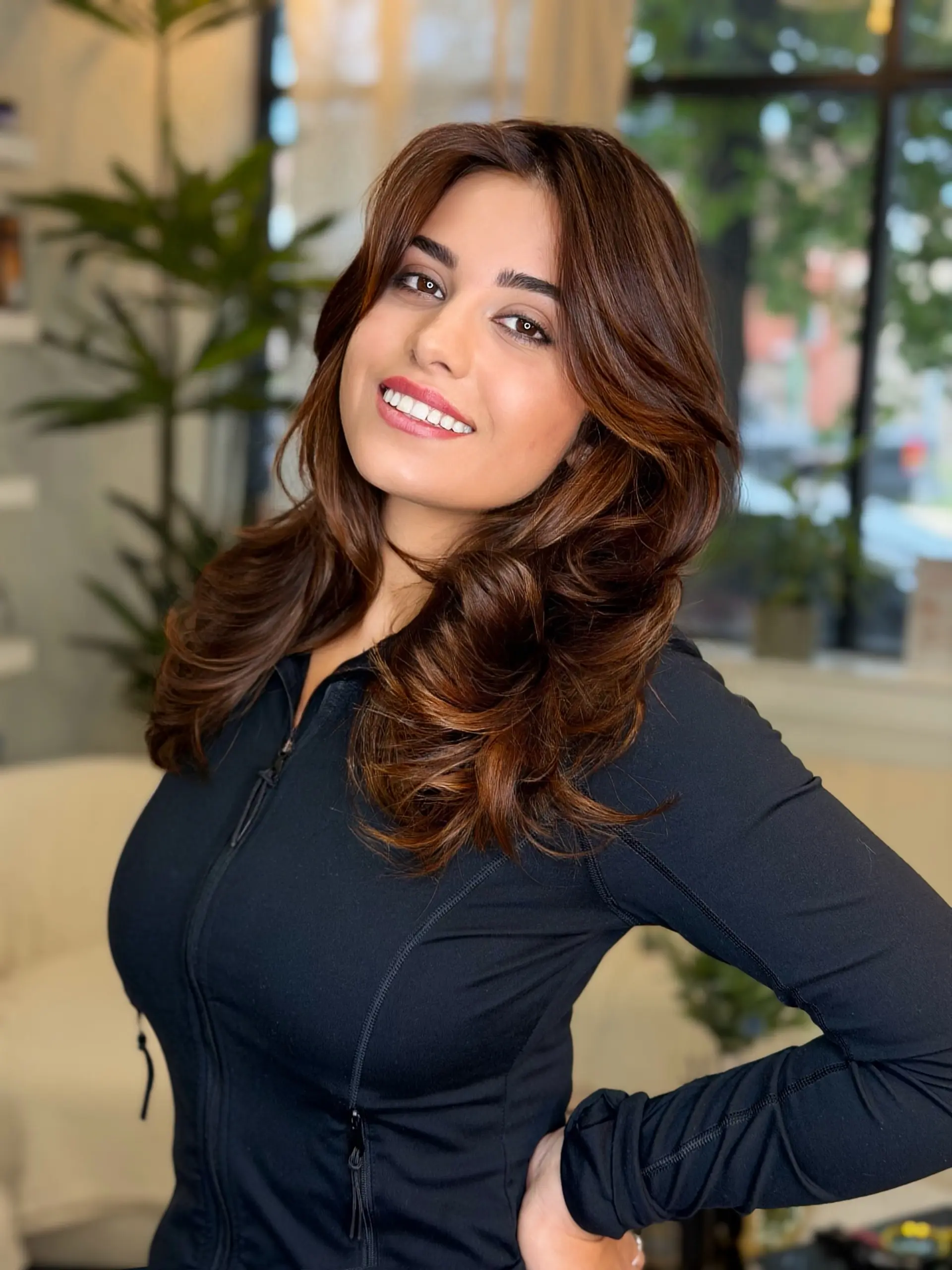 Medium-length chestnut brunette hair styled in a voluminous blowout with soft face-framing layers and sweeping curls. 1