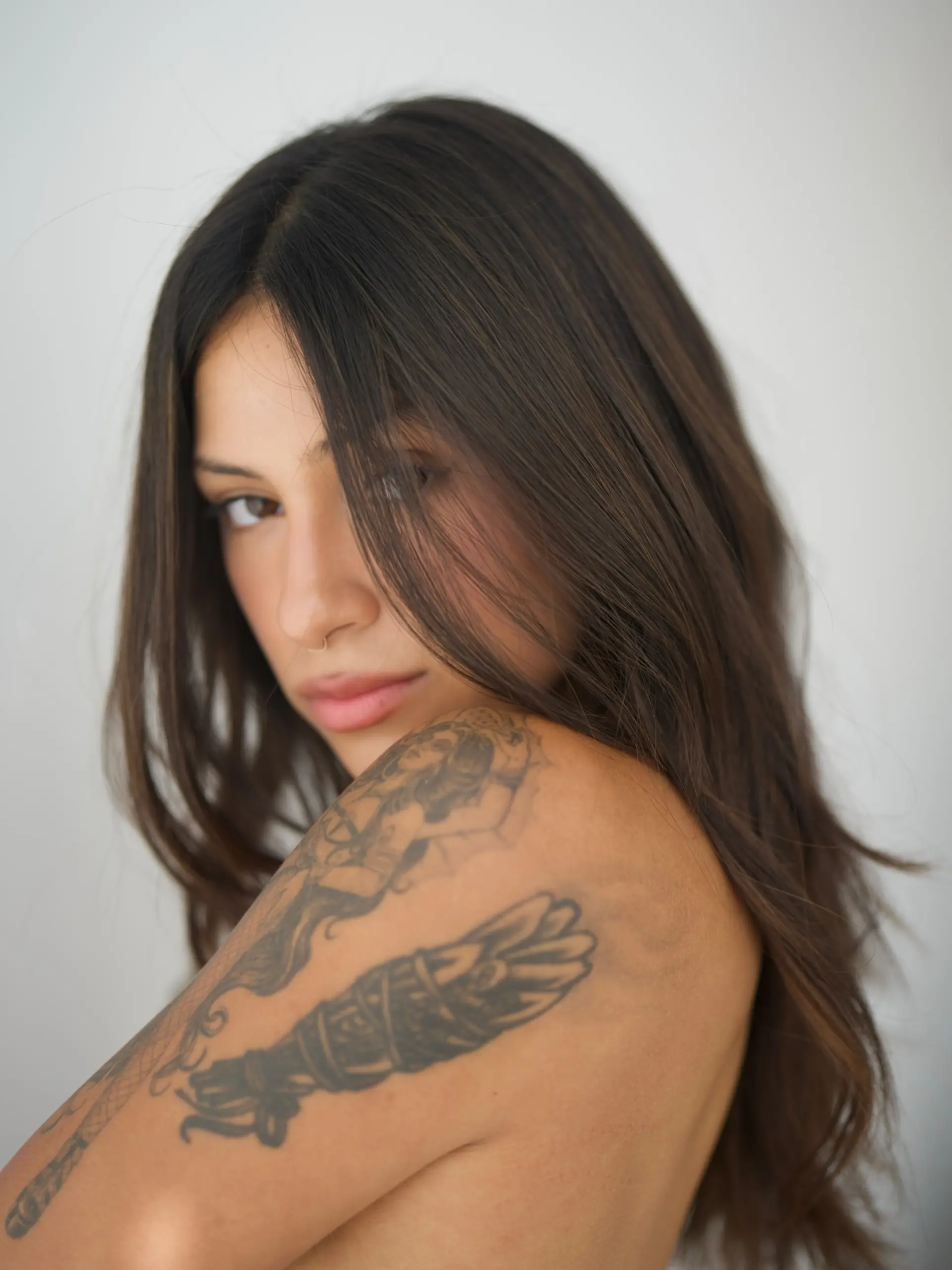 Long, rich dimensional brunette hair styled with soft, lived-in texture and subtle face-framing strands. 1