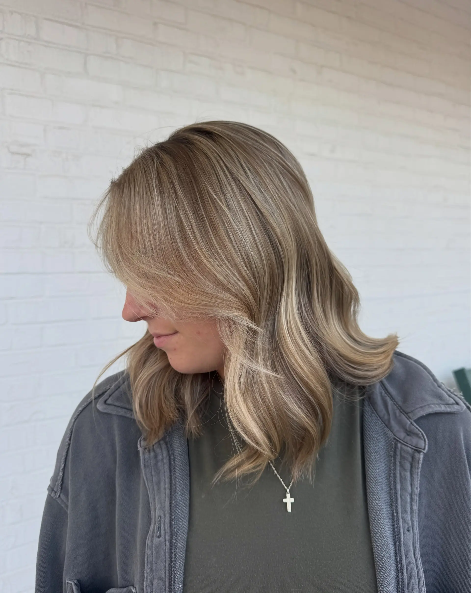 Medium-length vanilla blonde hair styled with soft, flipped ends and long face-framing fringe. 1
