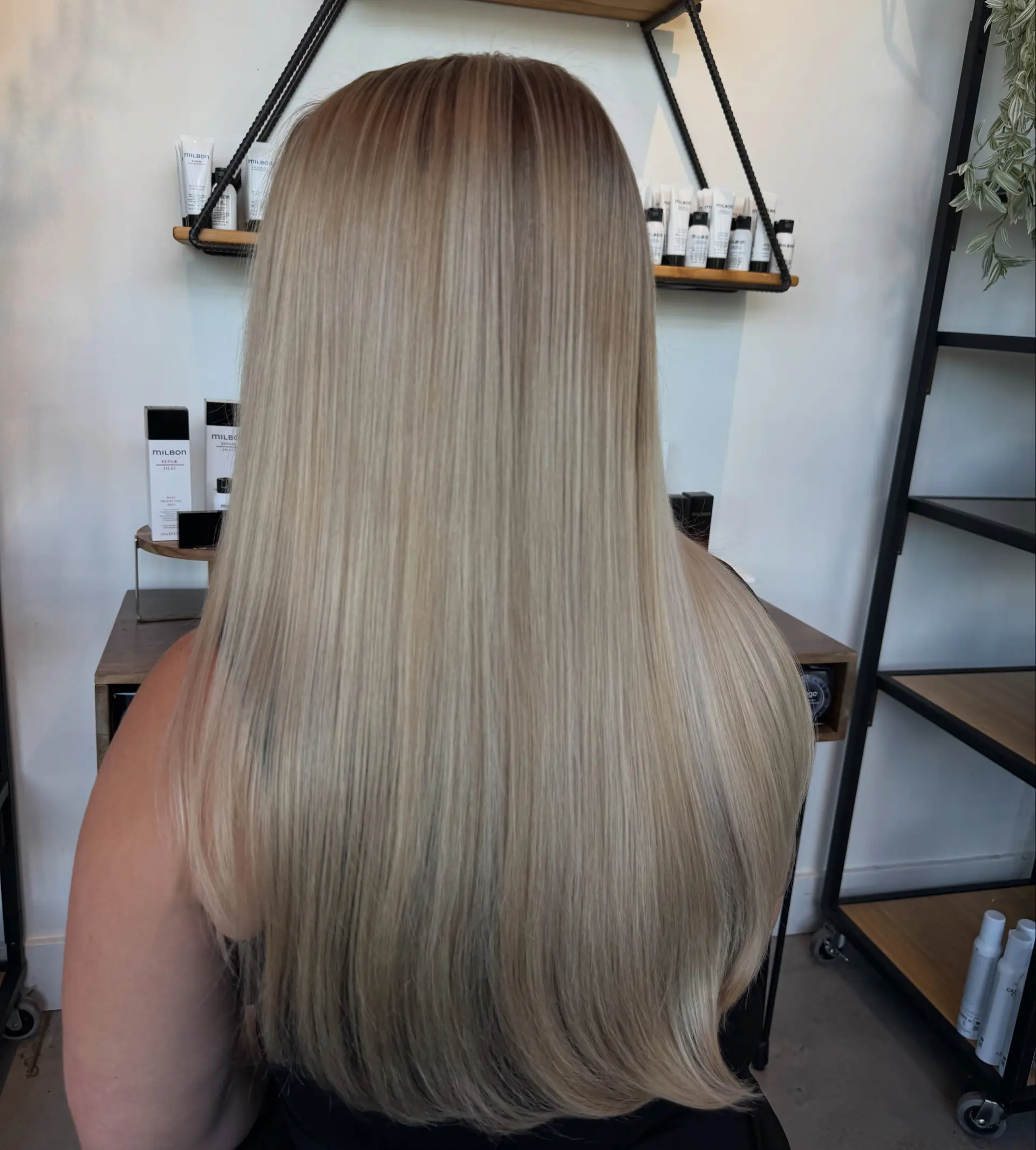Long, silky straight blonde hair featuring a soft shadow root and seamless blended highlights. 1