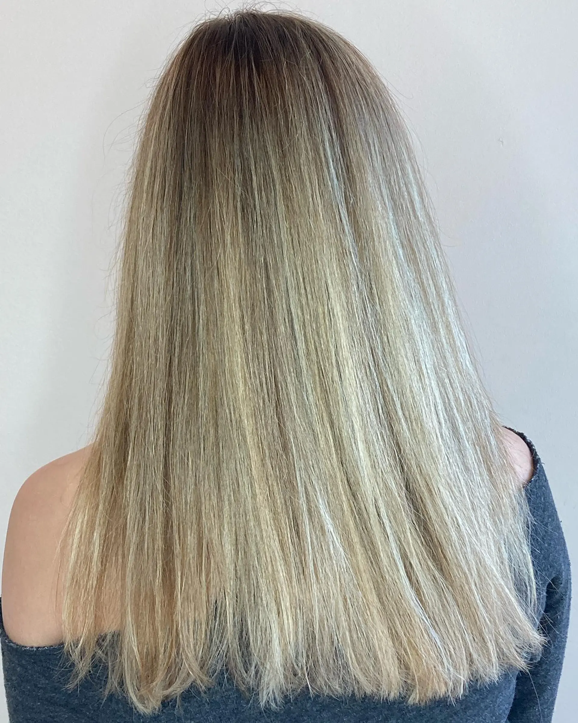 Straight long hair styled sleek and smooth, showcasing a multi-tonal lived-in blonde balayage with seamless root blending. 1